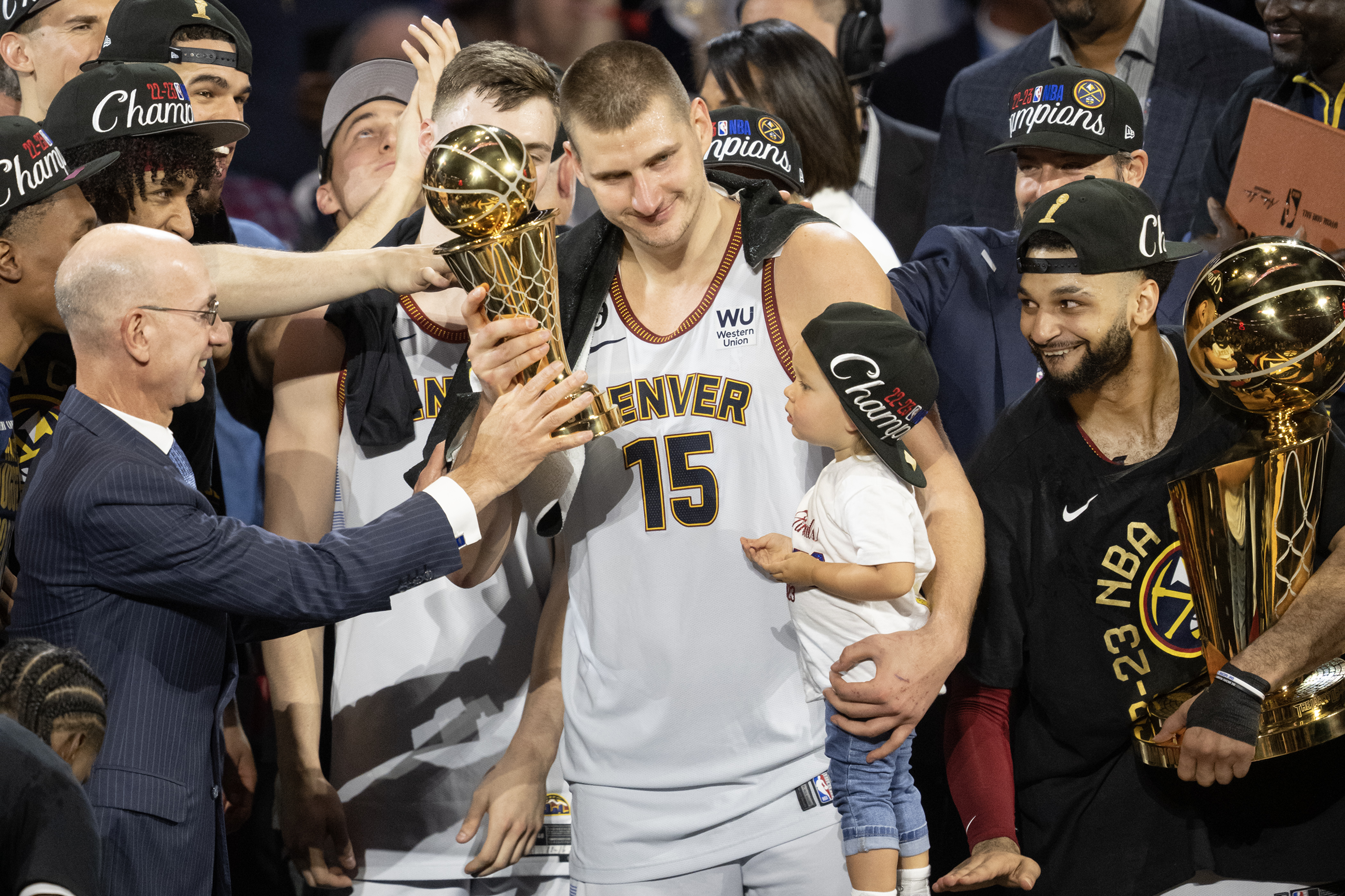 Denver Nuggets center Nikola Jokic (15) briefly picks up the Bill Russell NBA Finals Most Valuable Player Award while holding his daughter Ognjena after a 94-89 win over the Miami Heat in Game 5 of the NBA Finals on Monday, June 12, 2023, at Ball Arena in Denver. (Timothy Hurst/Denver Gazette) (Timothy Hurst/Denver Gazette)