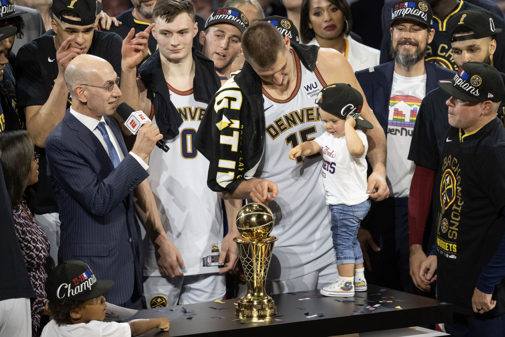 Denver Nuggets center Nikola Jokic (15) points out the Bill Russell NBA Finals Most Valuable Player Award to his daughter Ognjena after a 94-89 win over the Miami Heat in Game 5 of the NBA Finals on Monday, June 12, 2023, at Ball Arena in Denver. (Timothy Hurst/Denver Gazette) (Timothy Hurst/Denver Gazette)