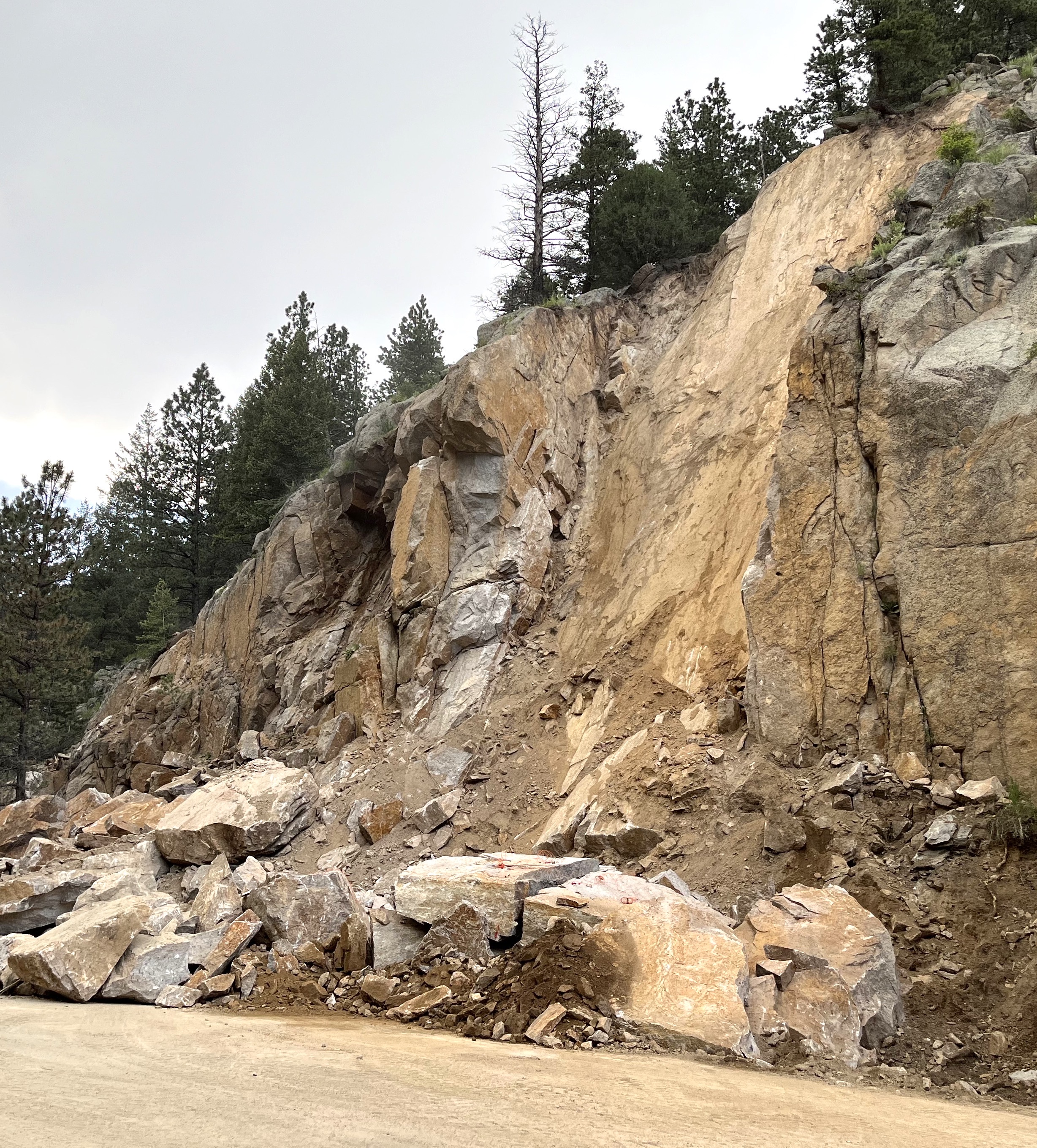 While clearing rock from a rockslide on Colorado Highway 7 between Lyons and Allenspark CDOT discovered a “fracture plane” chute where the slide occurred with more fractured rock that must be removed. CDOT is using airbags in the cracks of the rock to the left in the photo to bring down the unstable rock. (Courtesy of Colorado Department of Transportation)