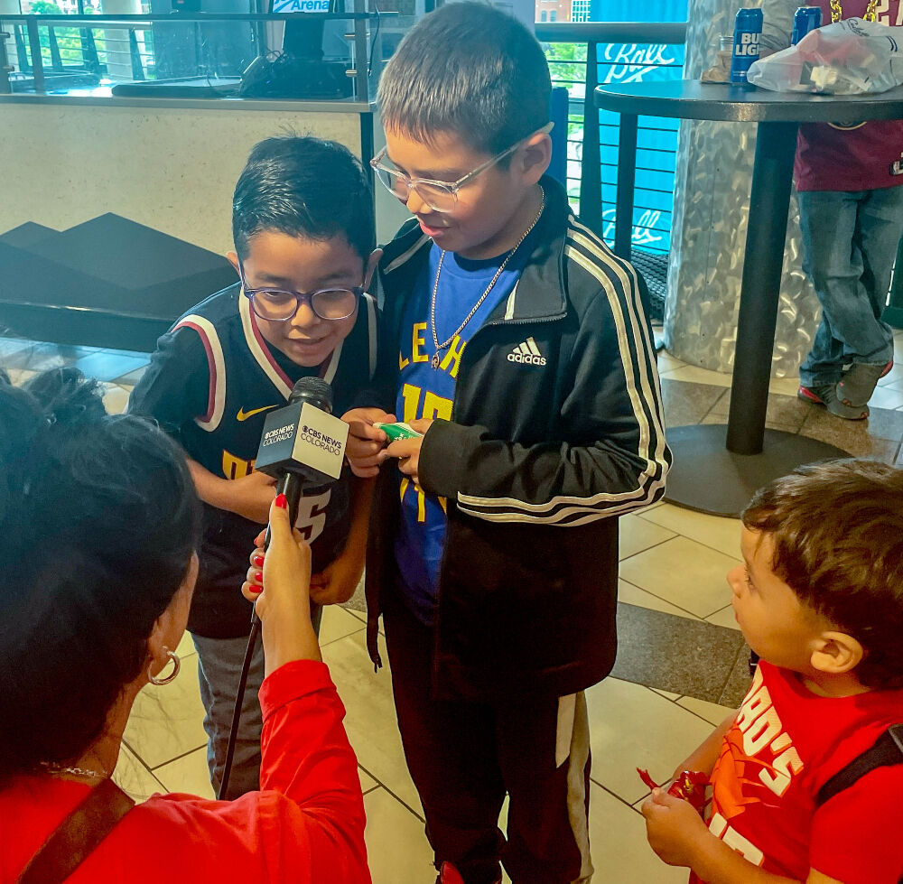 Young children are interviewed by a local journalist at the Denver Nuggets' NBA Finals Game 3 watch party at Ball Arena on Wednesday night. (John Moore/The Denver Gazette)