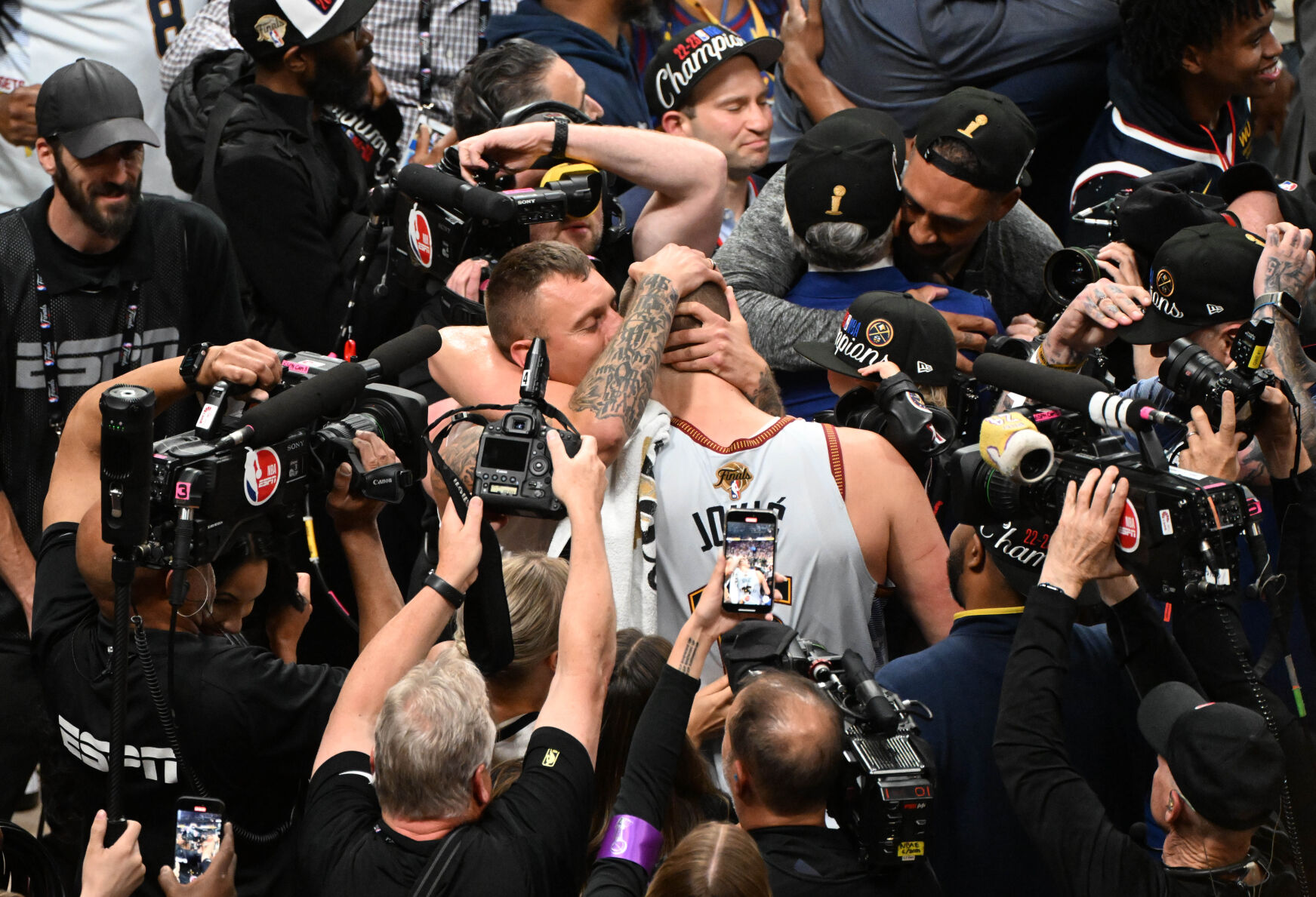 Denver Nuggets center Nikola Jokic (15) is kissed by his brother, Nemanja Jokic, while surrounded by cameras after winning the NBA Championship at Ball Arena on Monday, June 12, 2023. (Photo by Jerilee Bennett, The Gazette)