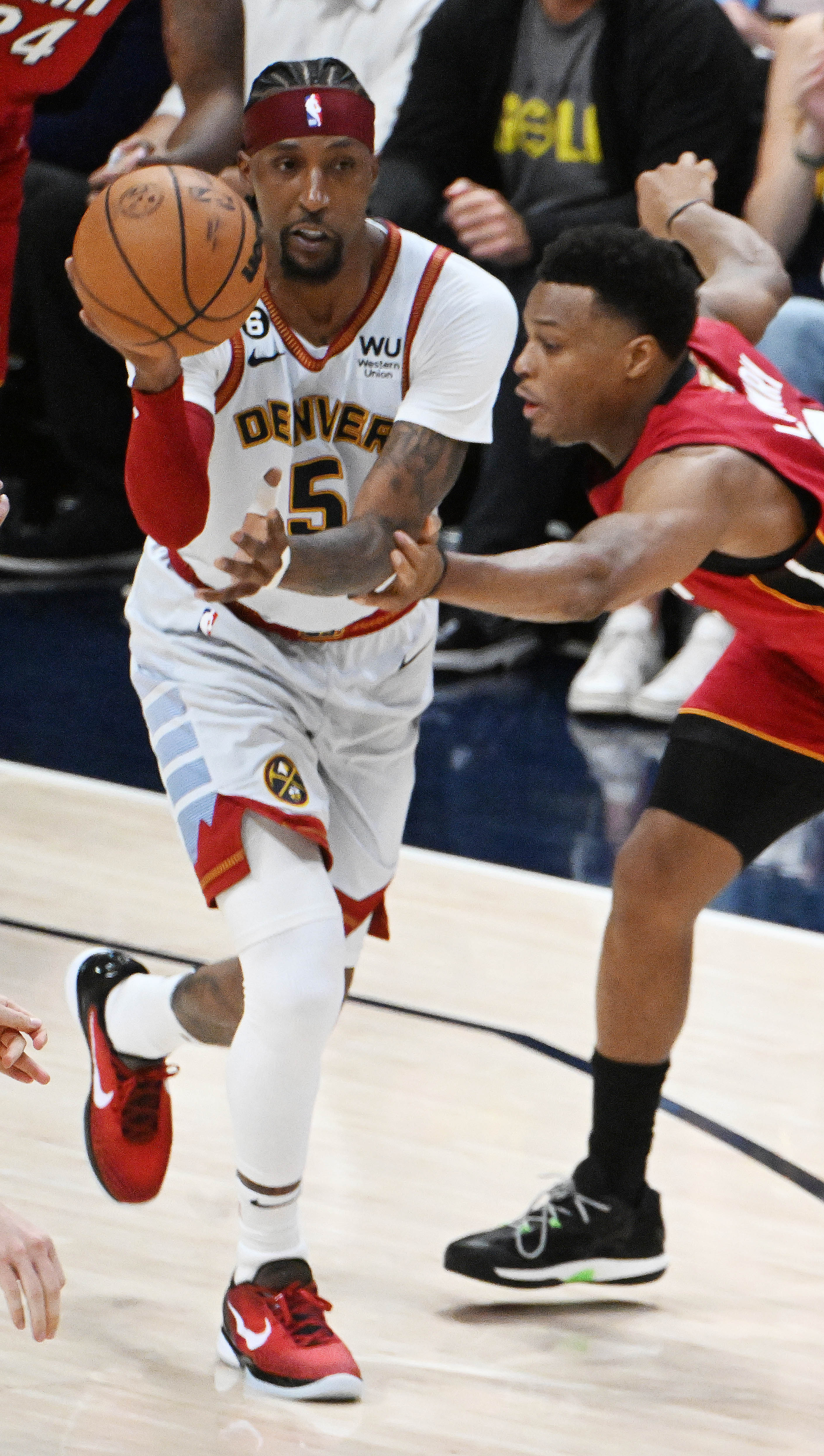 Denver Nuggets guard Kentavious Caldwell-Pope (5) pass the ball past Miami Heat forward Nikola Jovic (5) during the 2nd quarter of game 5 of the NBA Finals at Ball Arena on Monday, June 12, 2023. (Photo by Jerilee Bennett, The Gazette)