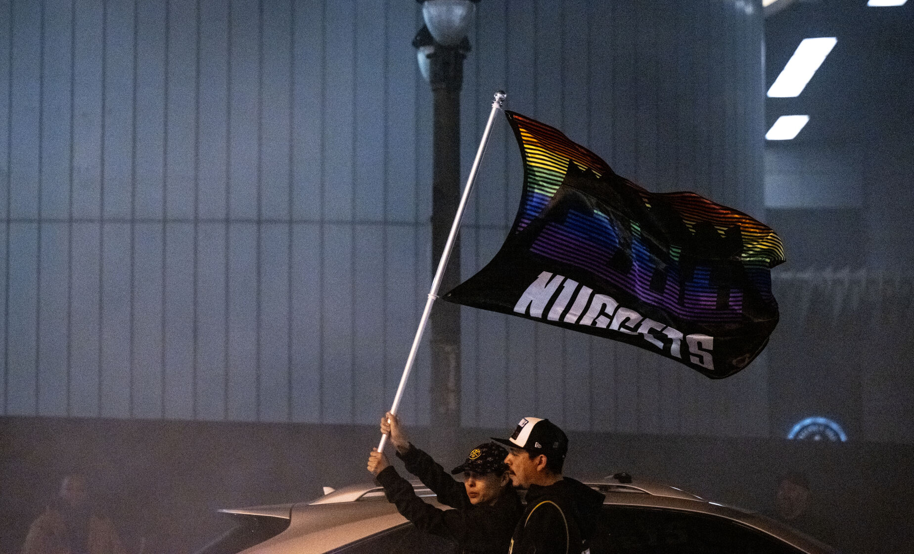 Nuggets fans hold a flag high above their heads as they walk through the streets of Denver on Monday, June 12, 2023. (Parker Seibold, The Gazette) (Parker Seibold)