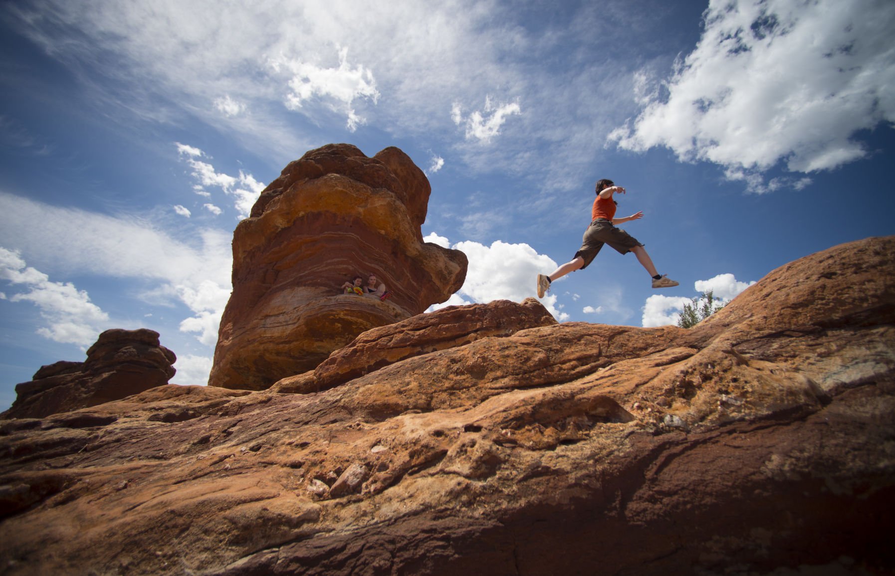 Michelle Ennis leaps from rock to rock while visiting Balanced Rock in Garden of the Gods Monday, June 23, 2014. Ennis is visiting from Chicago and said this was her first ever visit to the park that online travel site TripAdvisor recently named the No. 1 park in the country. The city of Colorado Springs estimates that roughly 2 million people visit the park every year. Photo by Mark Reis, The Gazette (Garden of the Gods. Mark Reis)
