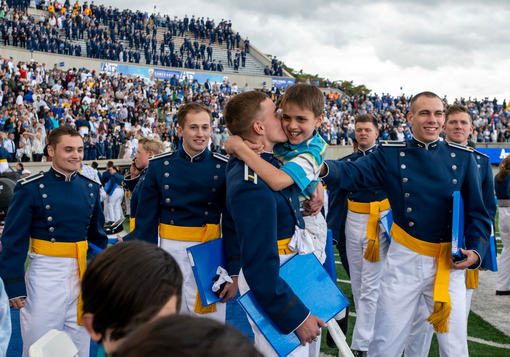 Air Force Academy graduate Joseph Hughes gives a hug and a kiss to his little brother Mathew after the Air Force Academy graduation ceremony at Falcon Stadium on Thursday, June 1, 2023. (Parker Seibold, The Gazette) (Parker Seibold)