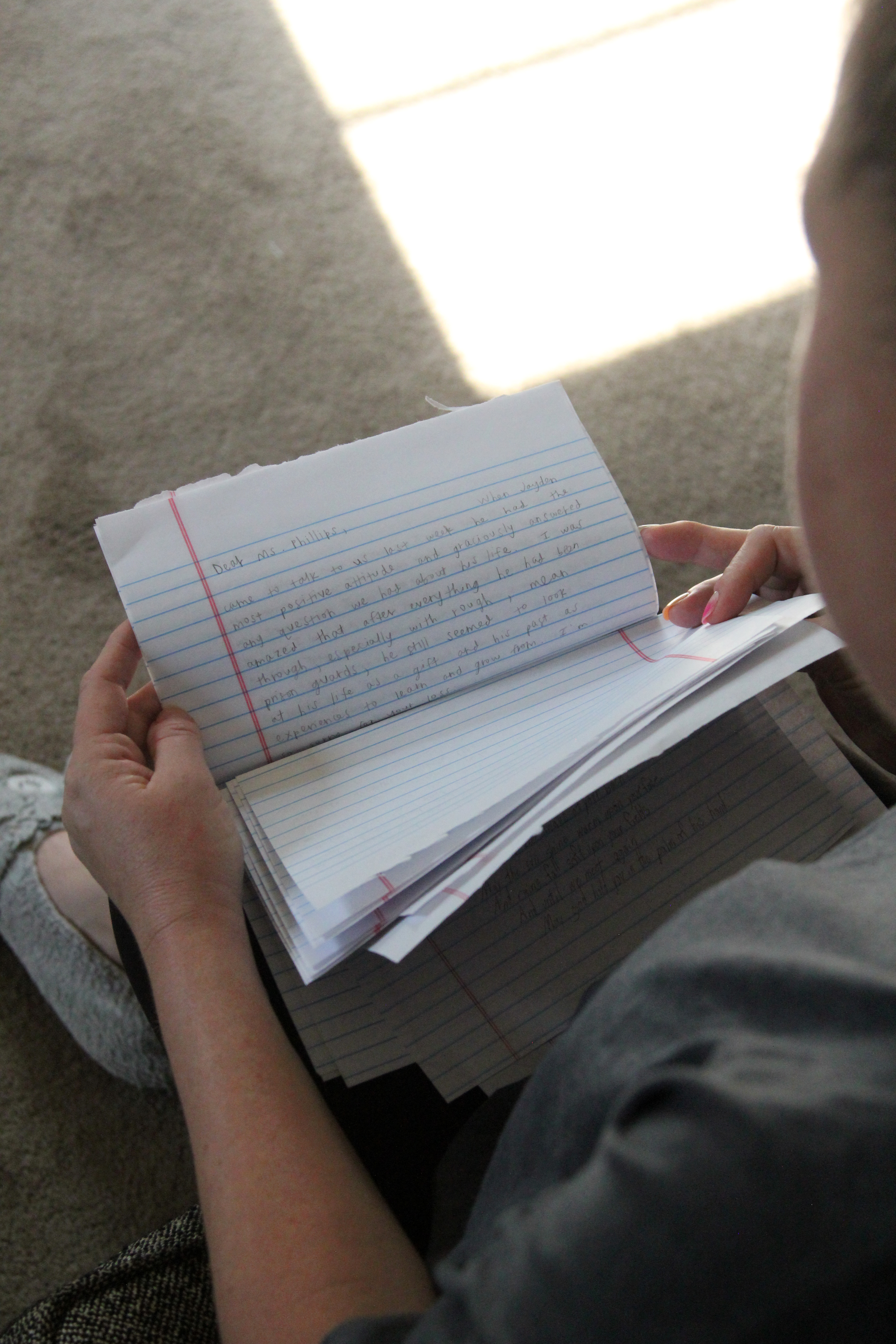 Lisa Phillips looks at letters from criminal justice students who met her son, Jayden, before his death in October 2021. (Jessica Gibbs)