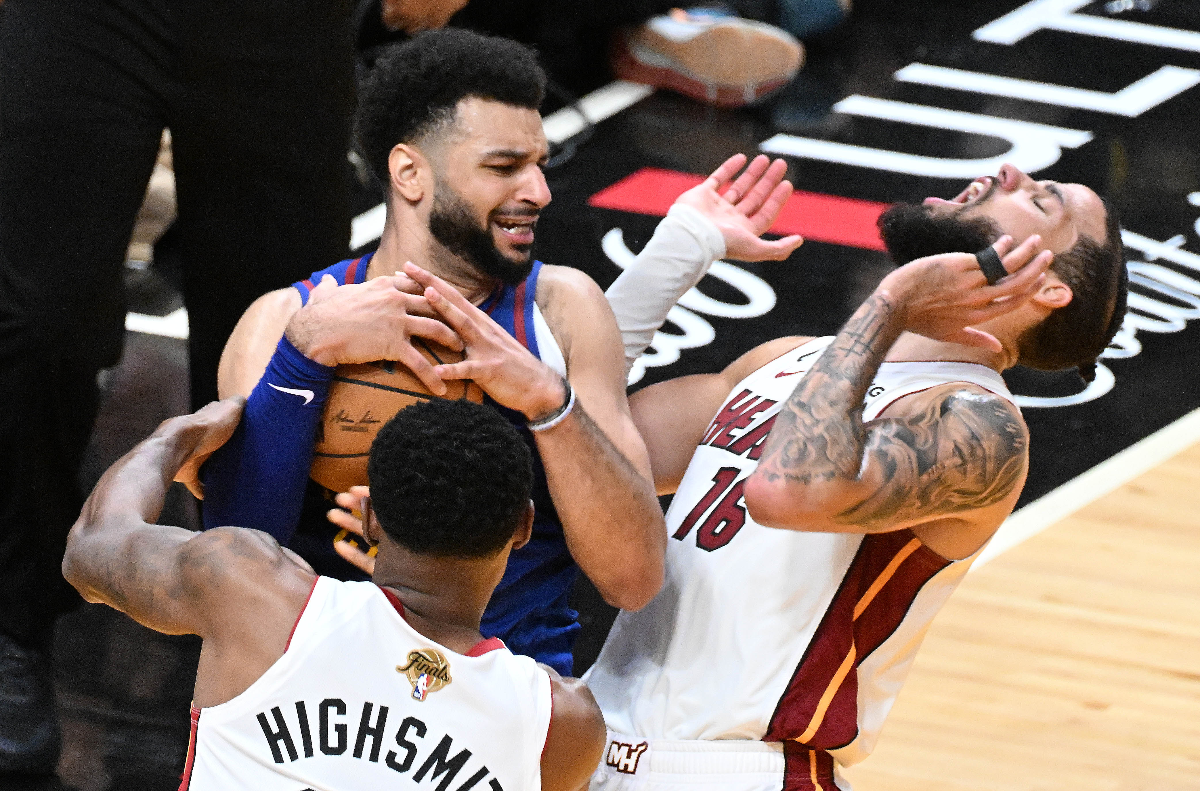Denver Nuggets guard Jamal Murray (27) and Miami Heat forward Haywood Highsmith (24) fight for the ball while Miami Heat forward Caleb Martin (16) does a little acting in the 4th quarter of the game 3 at at the Kaseya Center in Miami during the first quarter of Game 3 of the NBA Finals on Wednesday, June 7, 2023. (Photo by Jerilee Bennett, The Gazette)