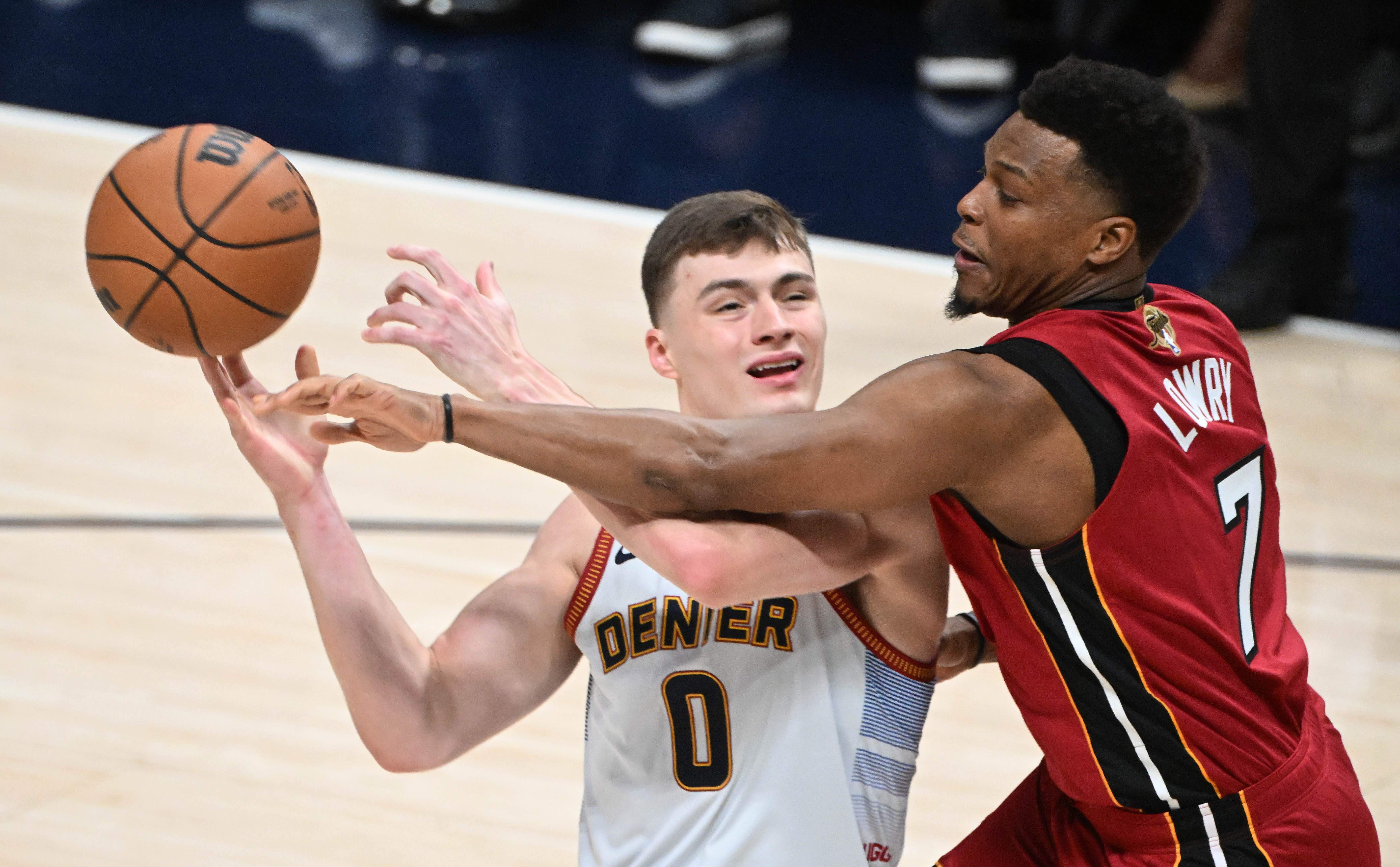 Denver Nuggets guard Christian Braun (0) gets the ball knocked out of his hands by Miami Heat guard Kyle Lowry (7)) during the first quarter of game 5 of the NBA Finals at Ball Arena on Monday, June 12, 2023. (Photo by Jerilee Bennett, The Gazette)