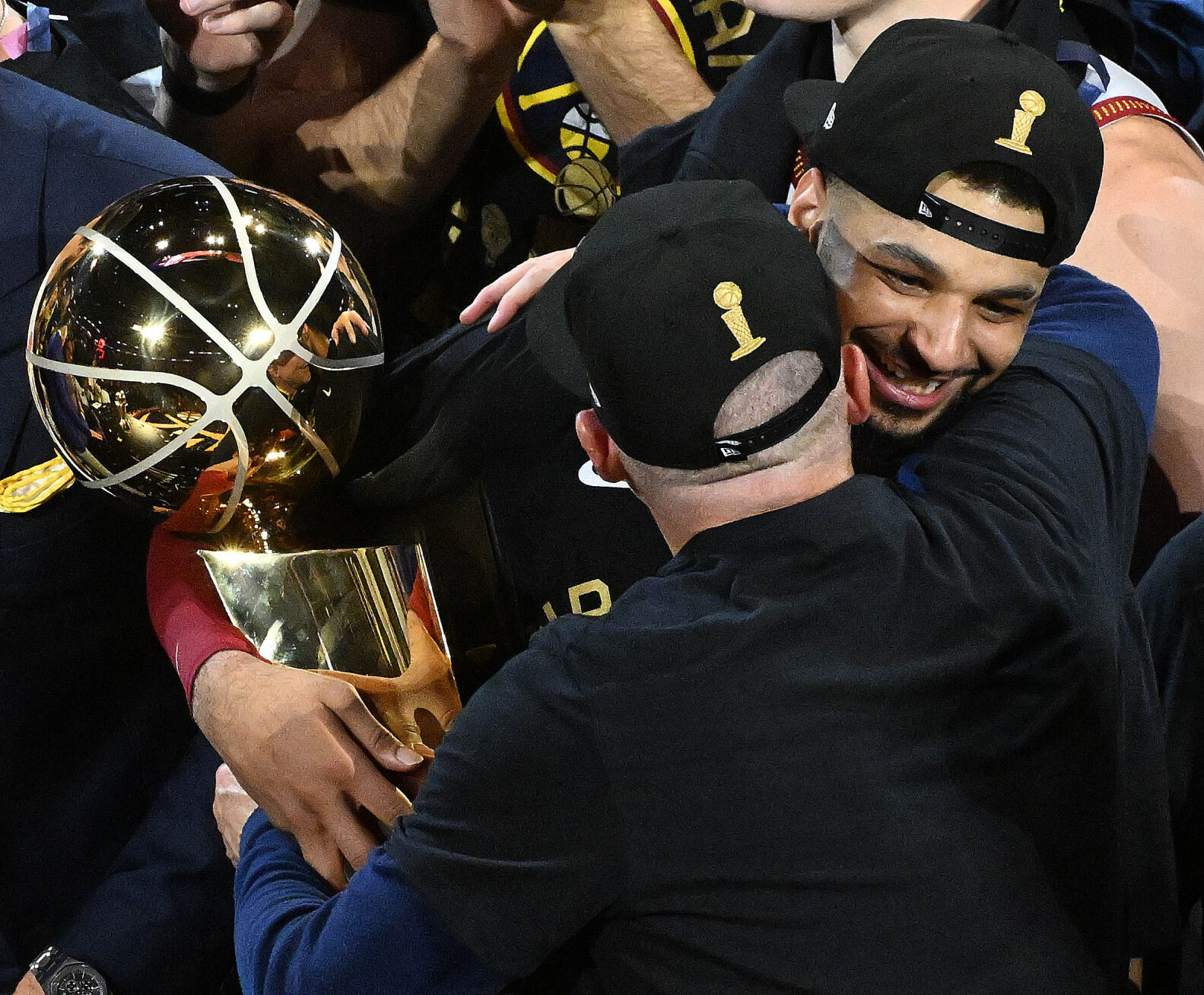 Denver Nuggets guard Jamal Murray (27) and Head Coach Michael Malone hug with the NBA Championship Trophy at Ball Arena on Monday, June 12, 2023. (Photo by Jerilee Bennett, The Gazette)