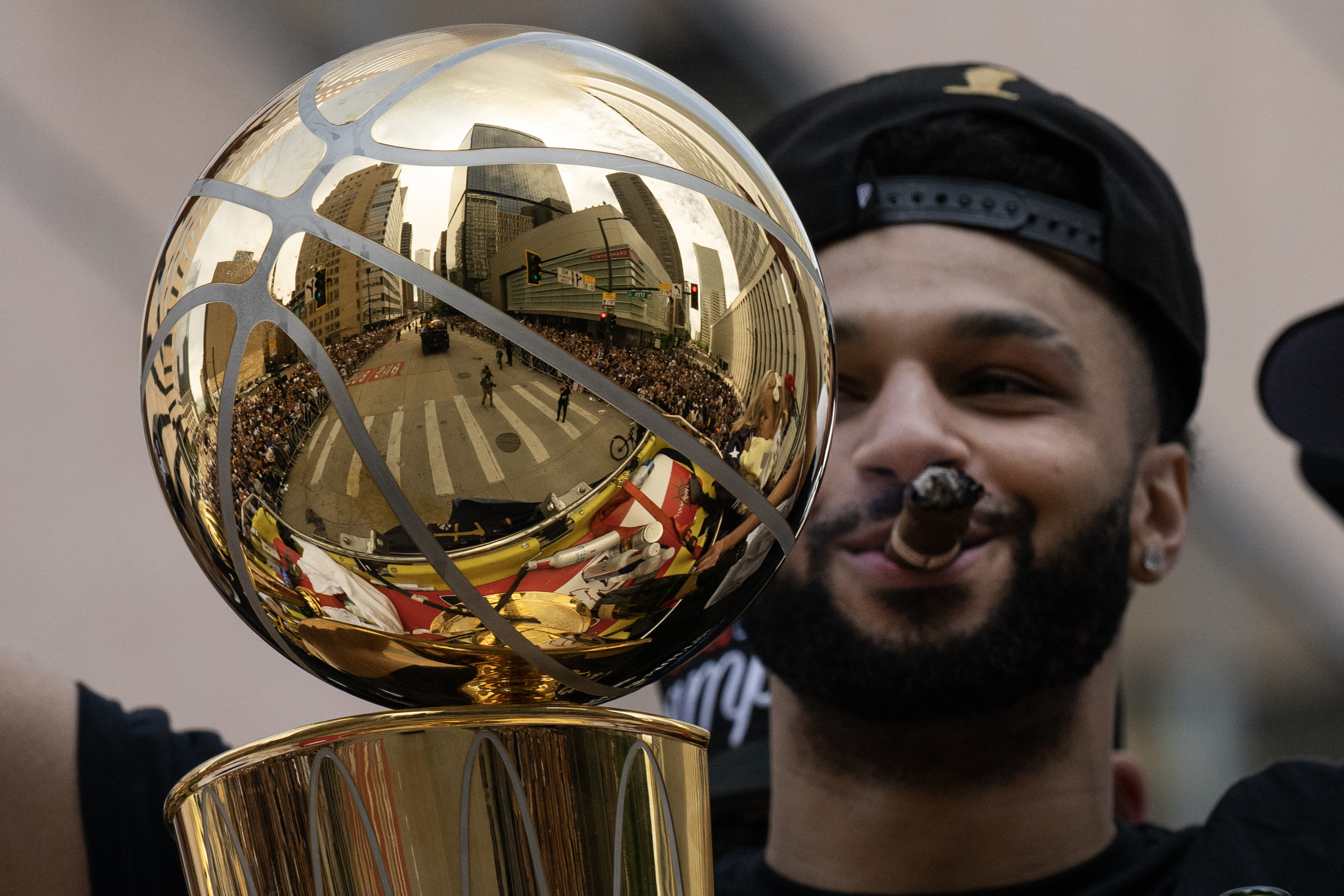 Denver Nuggets point guard Jamal Murray smokes a cigar while behind the Larry O’Brien Championship Trophy during the Denver Nuggets 2023 Champions Parade and Rally on Thursday, June 15, 2023, in Denver. (TimHursttim.hurst@gazette.comhttps://secure.gravatar.com/avatar/aca82bd62b4ee425c598527cd6faa1b1?d=mm&r=g)
