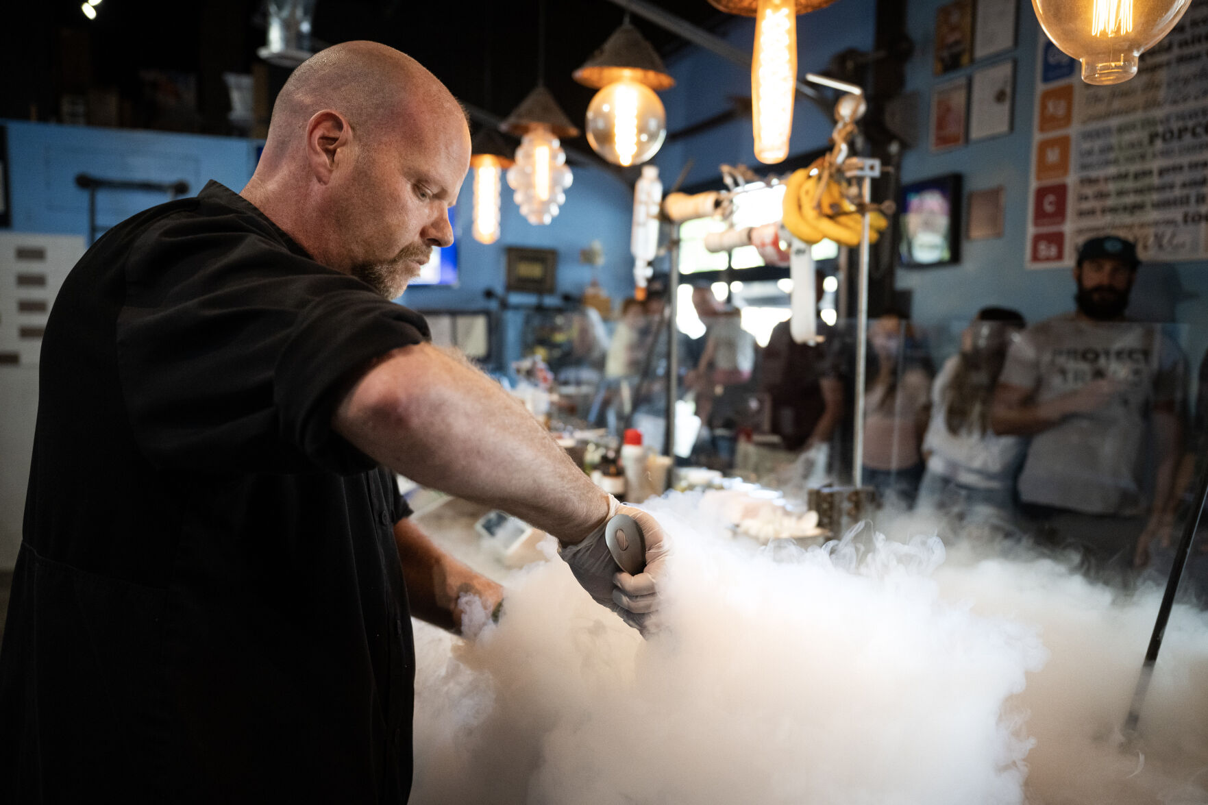 Guests look on from behind the counter as owner and chef Ian Kleinman mixes ice cream in a bowl while a plume of vaporizing nitrogen pours out during a demonstration at The Inventing Room in Denver. (TimHursttim.hurst@gazette.comhttps://secure.gravatar.com/avatar/aca82bd62b4ee425c598527cd6faa1b1?d=mm&r=g)
