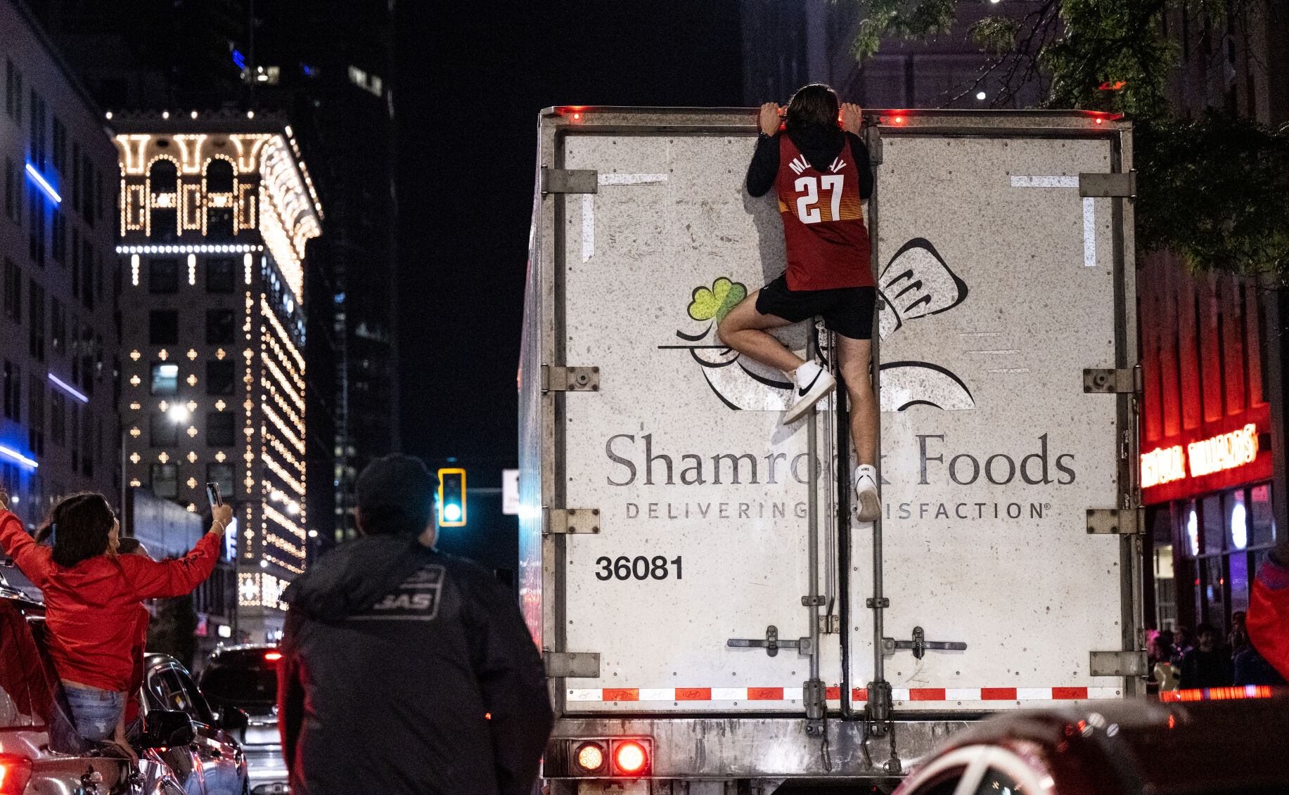 A Denver Nuggets fan climbs a moving semi-truck after the Nuggets won the NBA championship game on Monday, June 12, 2023. (Parker Seibold, The Gazette) (Parker Seibold)