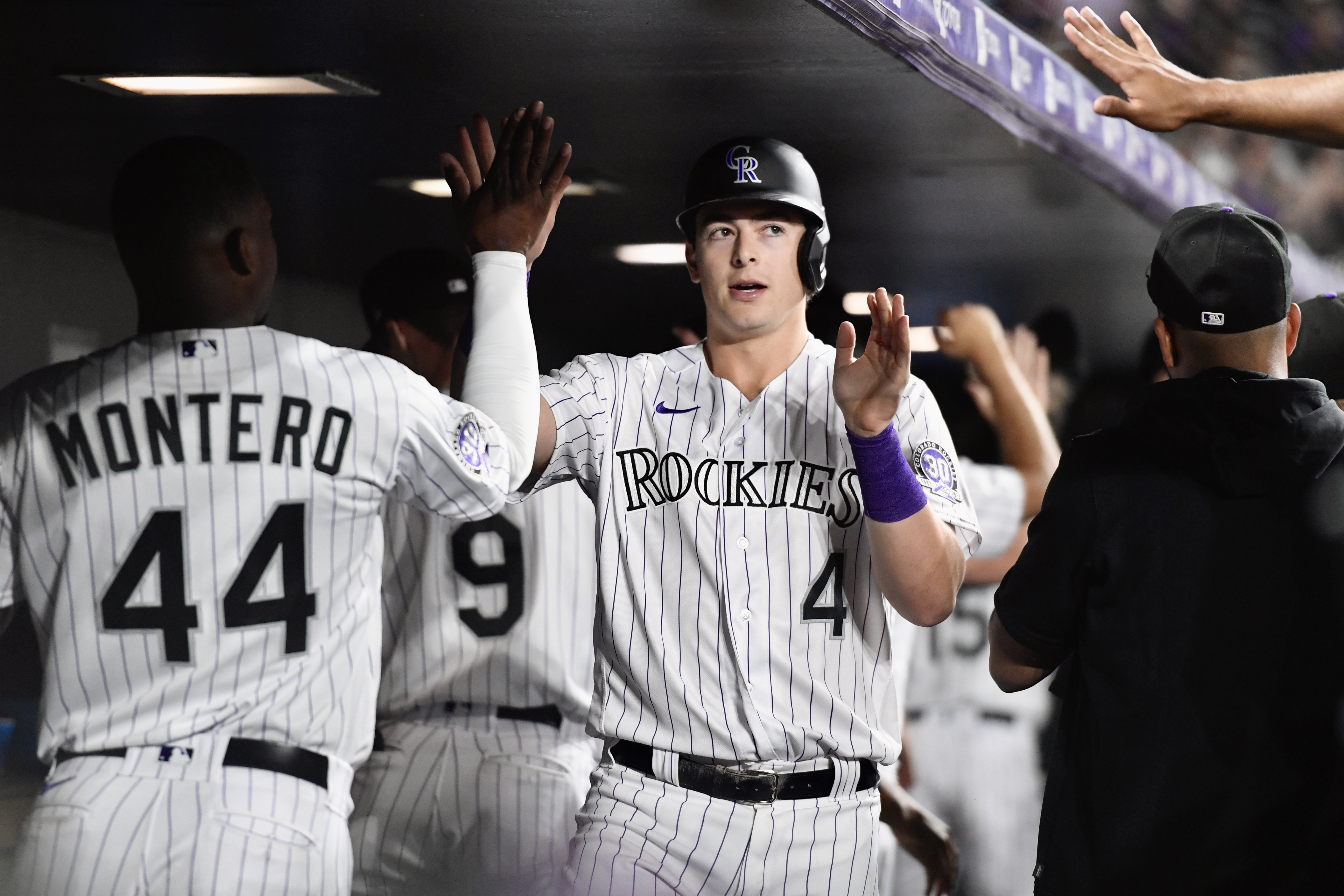 Rockies infielder Michael Toglia high-fives teammates after scoring against the Oakland Athletics on Friday, July 28, 2023. (CarsonFieldcarson.field@gazette.comhttps://secure.gravatar.com/avatar/c524ef3d384945349bed78d70eb2d2cd?d=mm&r=g)