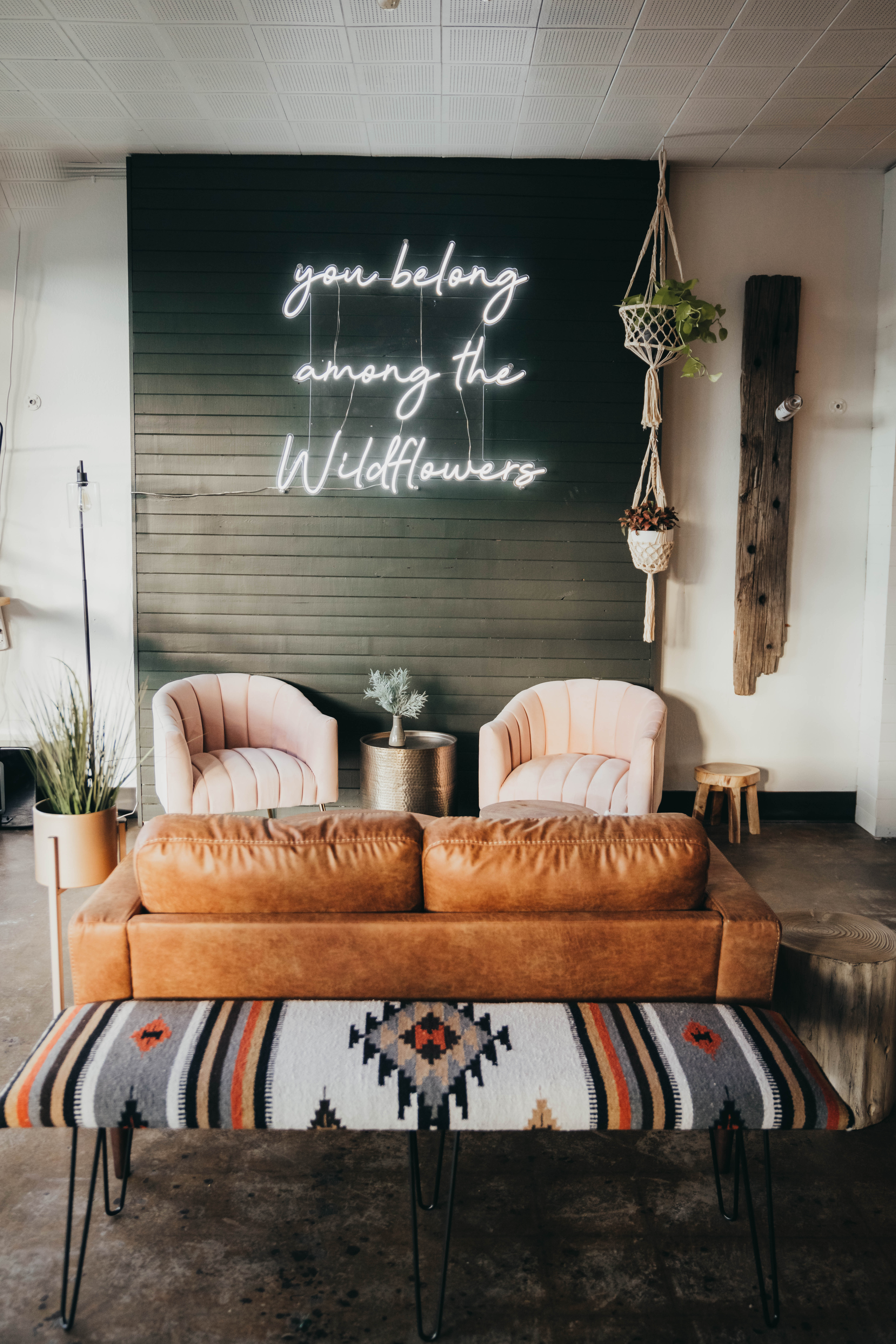 Wolf + Wildflower’s interior is perhaps best described as contemporary Western. The wooden bar and tables, a Pendleton bench and a neon Tom Petty lyric on wildflowers help combine the chic and rustic under one theme. (Courtesy Tamara McTavish Photography)