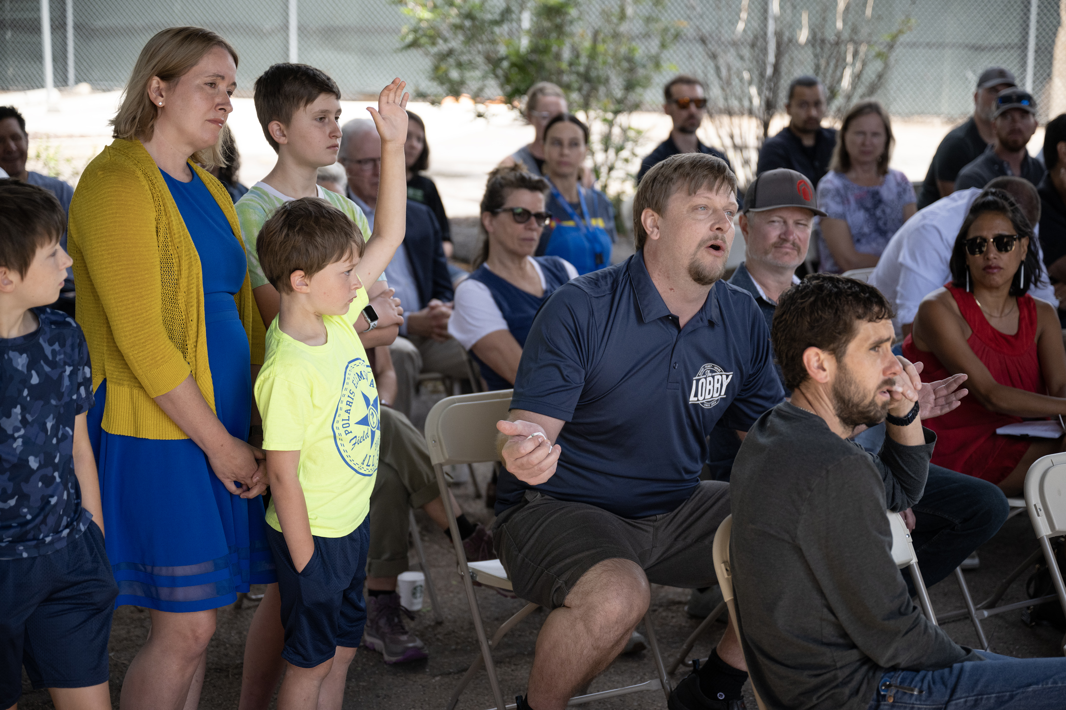Christian Batizy, the general manager at The Lobby American Grille, questions Denver Police officials about their strategy to enforce a camping ban in the city while seven-year-old Jonathan Guffey raises his hand to ask a question during a Commander Advisory Group Meeting at the Denver Police Department District 6 station on Thursday, July 20, 2023, in Denver, Colo. (Timothy Hurst/Denver Gazette) (TimHursttim.hurst@gazette.comhttps://secure.gravatar.com/avatar/aca82bd62b4ee425c598527cd6faa1b1?d=mm&r=g)