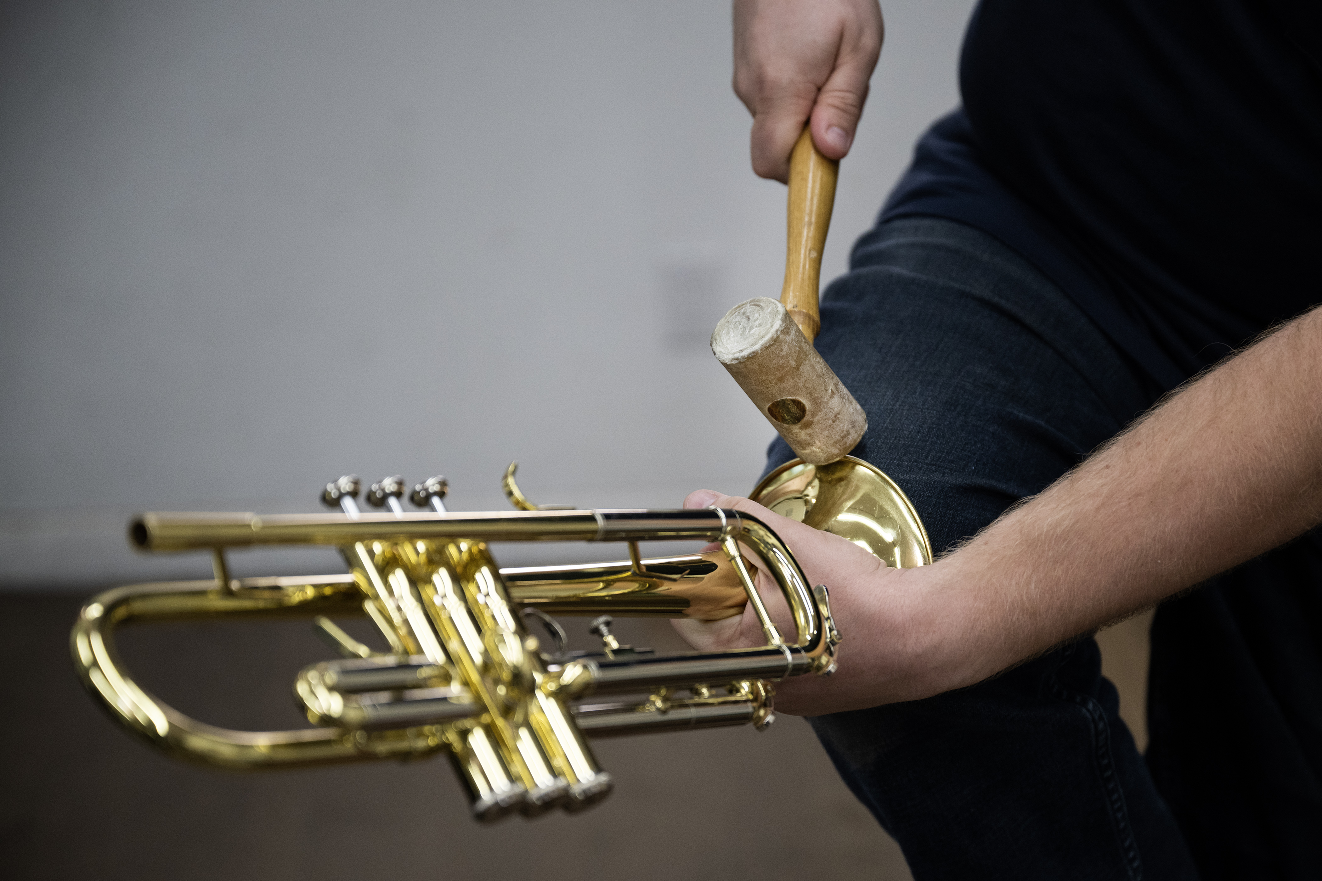 Brass repair technician Logan Krumtum uses a soft-faced mallet and his knee to straighten the rim of trumpet bell on Monday, July 17, 2023, at Kolacny Music Co. in Denver, Colo. (Timothy Hurst/Denver Gazette) (TimHursttim.hurst@gazette.comhttps://secure.gravatar.com/avatar/aca82bd62b4ee425c598527cd6faa1b1?d=mm&r=g)