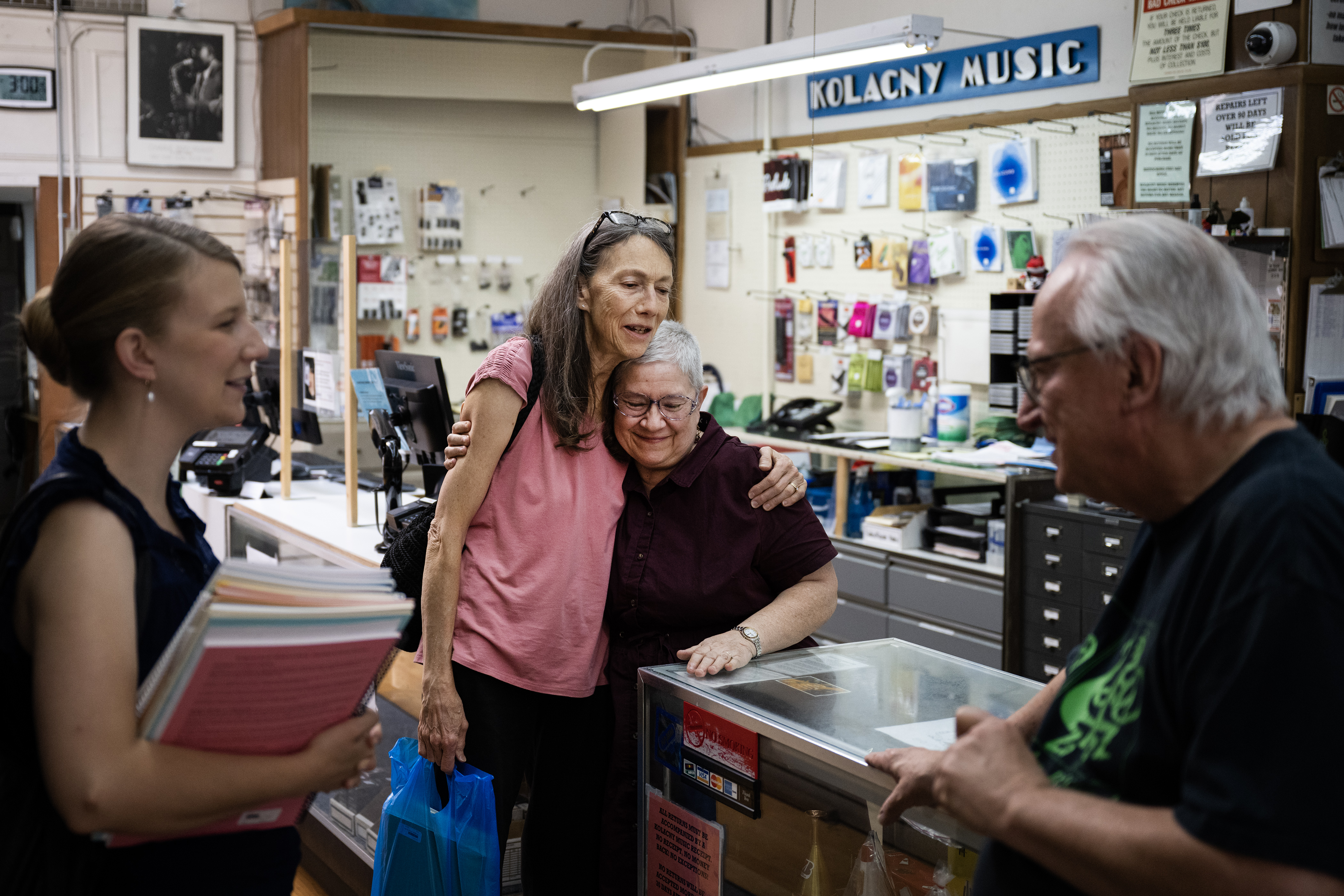 Longtime customer Debbie Hickox, center-left, hugs co-owner Debra Kolacny after Hickox and her daughter Alisa DeWitt, President of The Mile High Chapter of the American Harp Society, came in to buy hundreds of dollars in sheet music on Monday, July 17, 2023, at Kolacny Music in Denver, Colo. Word has gotten around the harpist community that Kolacny Music is closing, and in an effort to help them clear out inventory Hickox and DeWitt came in to buy sheet music. (Timothy Hurst/Denver Gazette) (TimHursttim.hurst@gazette.comhttps://secure.gravatar.com/avatar/aca82bd62b4ee425c598527cd6faa1b1?d=mm&r=g)