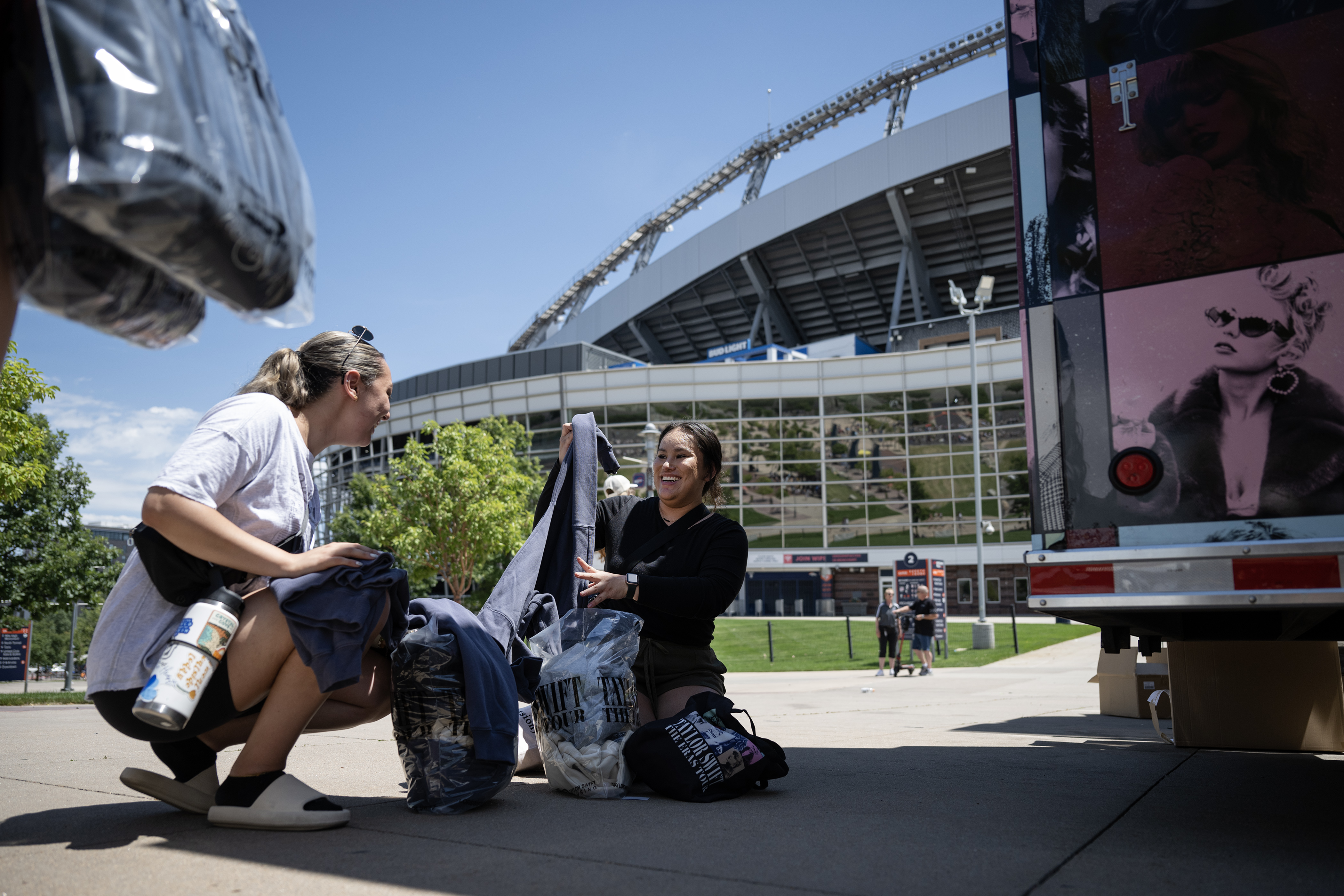 Taylor Swift fans Alexa Marquez, left, and Kiana Portillo go through their roughly $400 in merchandise while other fans wait in line to buy from the official merchandise truck outside of Empower Field at Mile High where she will be playing two shows the next two days, on Thursday, July 13, 2023, in Denver. (Timothy Hurst/Denver Gazette) (TimHursttim.hurst@gazette.comhttps://secure.gravatar.com/avatar/aca82bd62b4ee425c598527cd6faa1b1?d=mm&r=g)