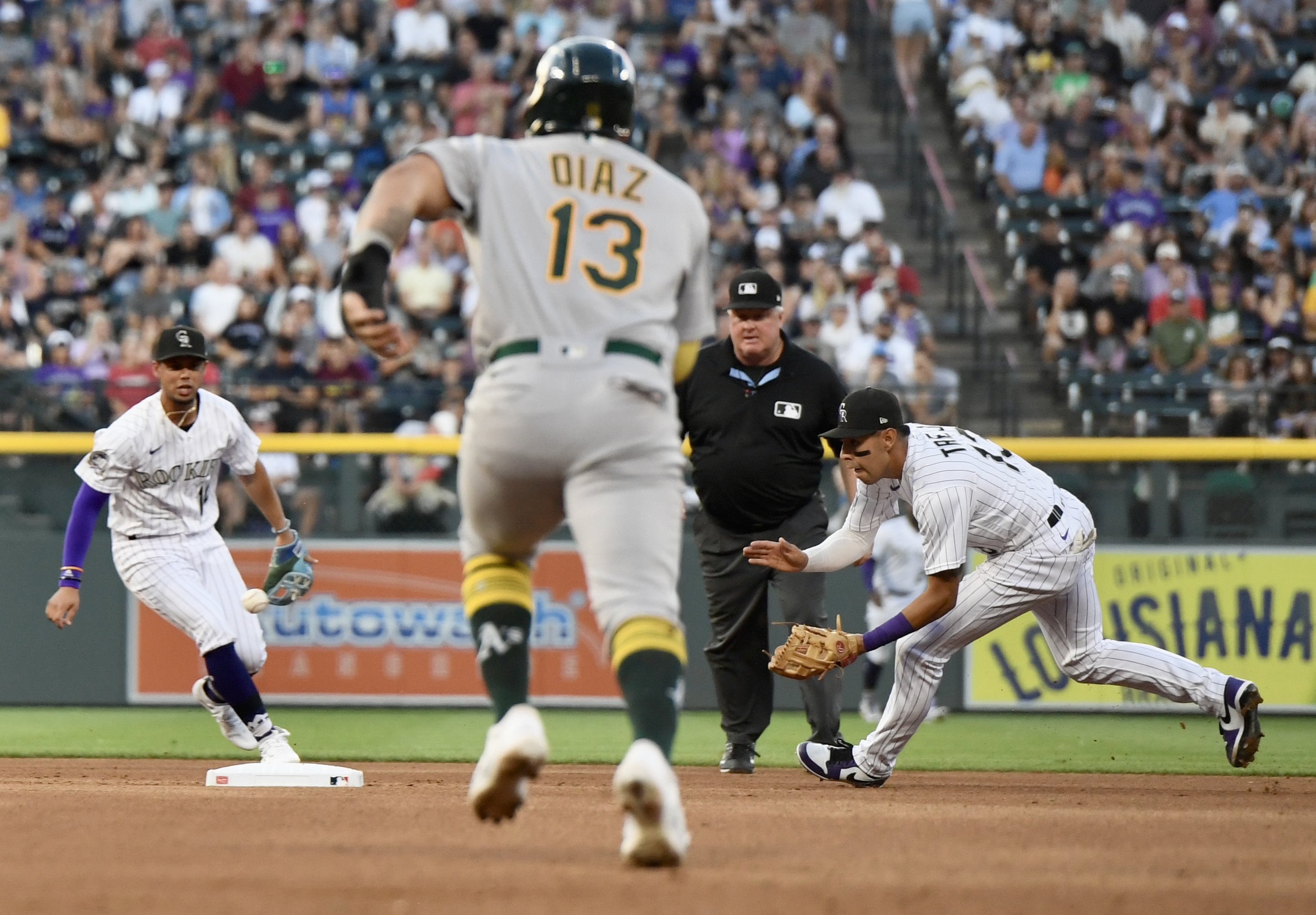 Rockies infielder Alan Trejo fields a ball as Athletics first baseman Jordan Diaz runs to second on Friday, July 28, 2023. (CarsonFieldcarson.field@gazette.comhttps://secure.gravatar.com/avatar/c524ef3d384945349bed78d70eb2d2cd?d=mm&r=g)