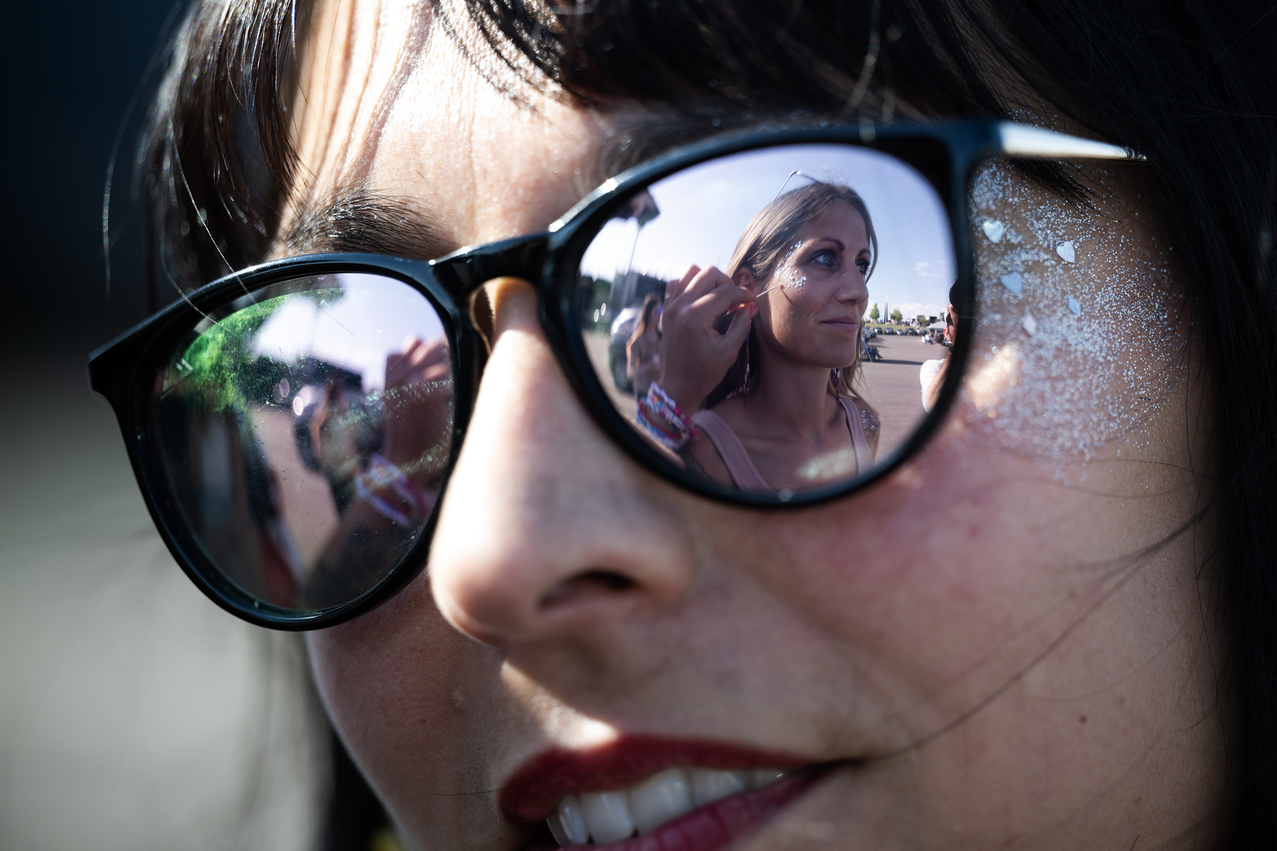 Jessy Tarquino applies sparkles and sequins to Kelsie Heermans cheek in the parking lot before the first of two Taylor Swift concerts at Empower Field at Mile High on Friday, July 14, 2023, in Denver, Colo. (Timothy Hurst/Denver Gazette) (Timothy Hurst/Denver Gazette)