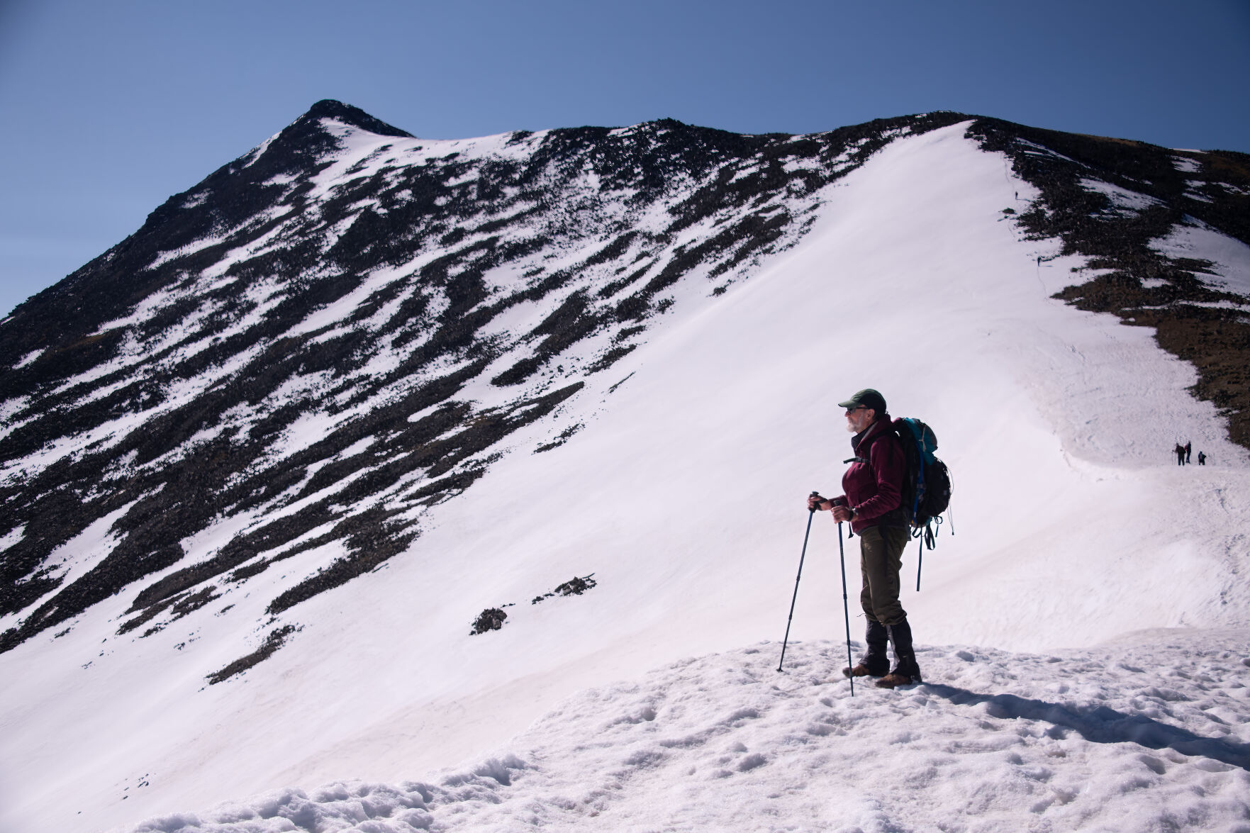Dan Crossey stands on a snowy ridge as he nears a “false summit” on his climb of Culebra Peak June 16, 2023. Crossey climbed his first fourteener 54 years earlier and always thought he’d remain a member of the ABC (All But Culebra) club. Photo by Mark Reis (Mark Reis)