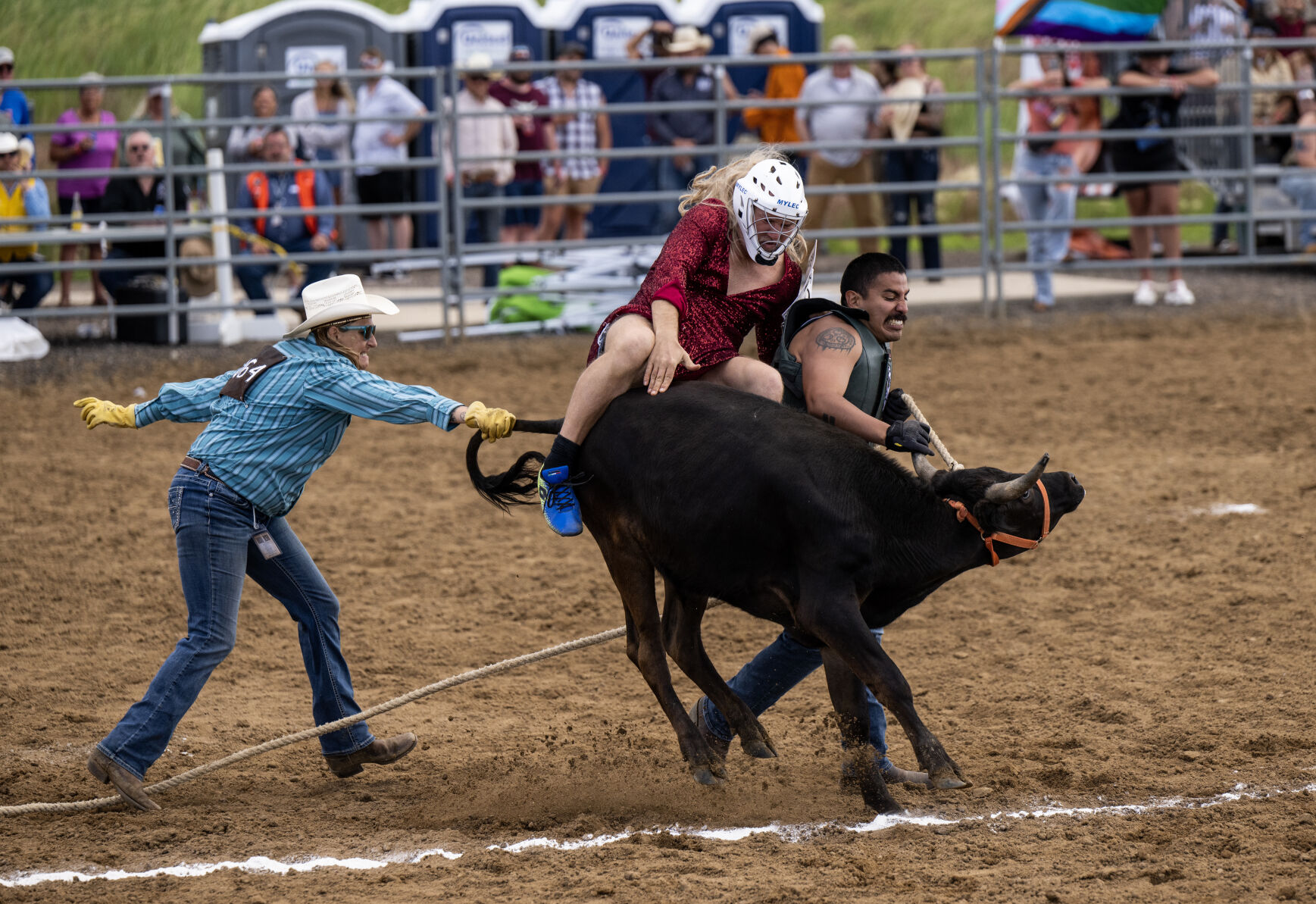 Ryan Villanueva hops on the back of a steer as Ashely Unruh, left, and Robbie Harrison-Garcia, right, try to keep it under control during wild drag race at the 40th Rocky Mountain Regional Rodeo held by the Colorado Gay Rodeo Association at the Arapahoe County Fairgrounds on Saturday, July 8, 2023. The CGA is the longest continuous running gay rodeo in the United States. (Parker Seibold, The Gazette) (Parker Seibold)