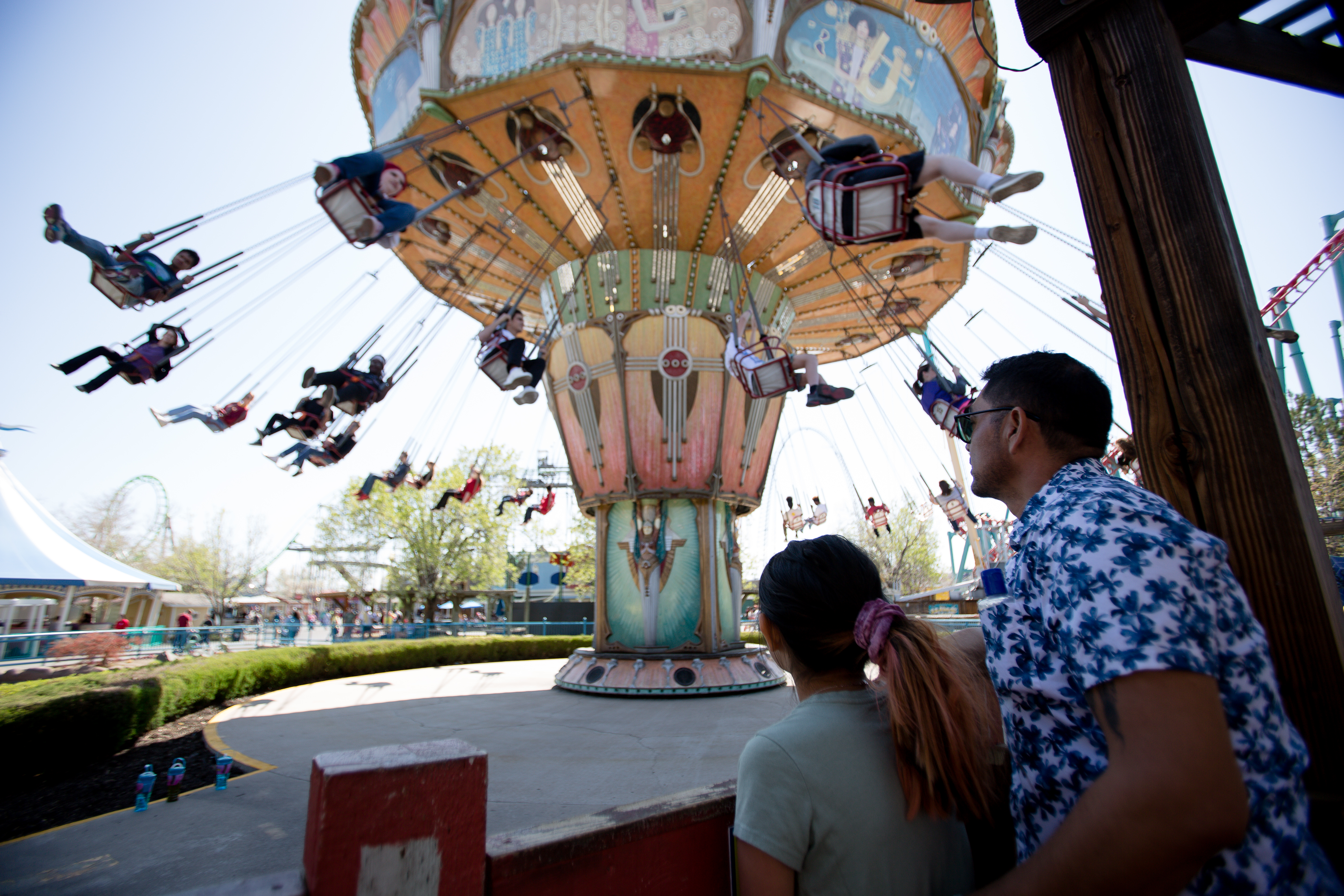Angel and Kayla Gonzales, 8, wait in line and watch people on the Turn of the Century ride during the first day of the 2022 season at Elitch Gardens, April 30, 2022. (Sara Hertwig/for The Denver Gazette) (Sara Hertwig/Special to The Denver Gazette)