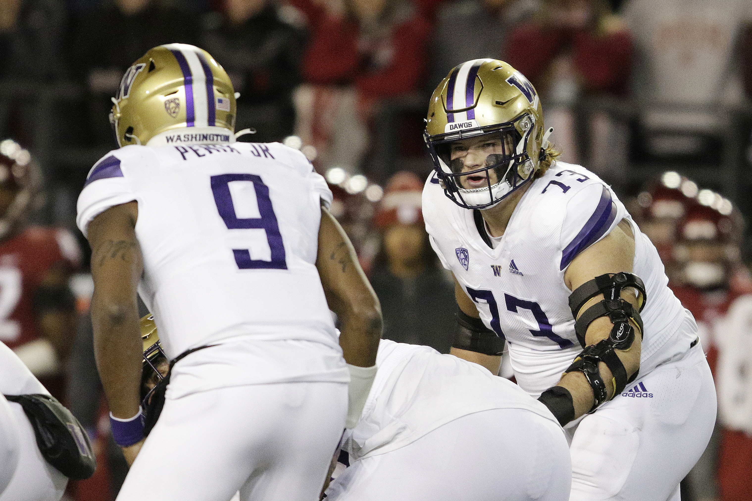 Washington offensive lineman Roger Rosengarten (73) looks over at quarterback Michael Penix Jr. (9) during the first half of an NCAA college football game against Washington State, Saturday, Nov. 26, 2022, in Pullman, Wash. (AP Photo/Young Kwak) (Young Kwak)