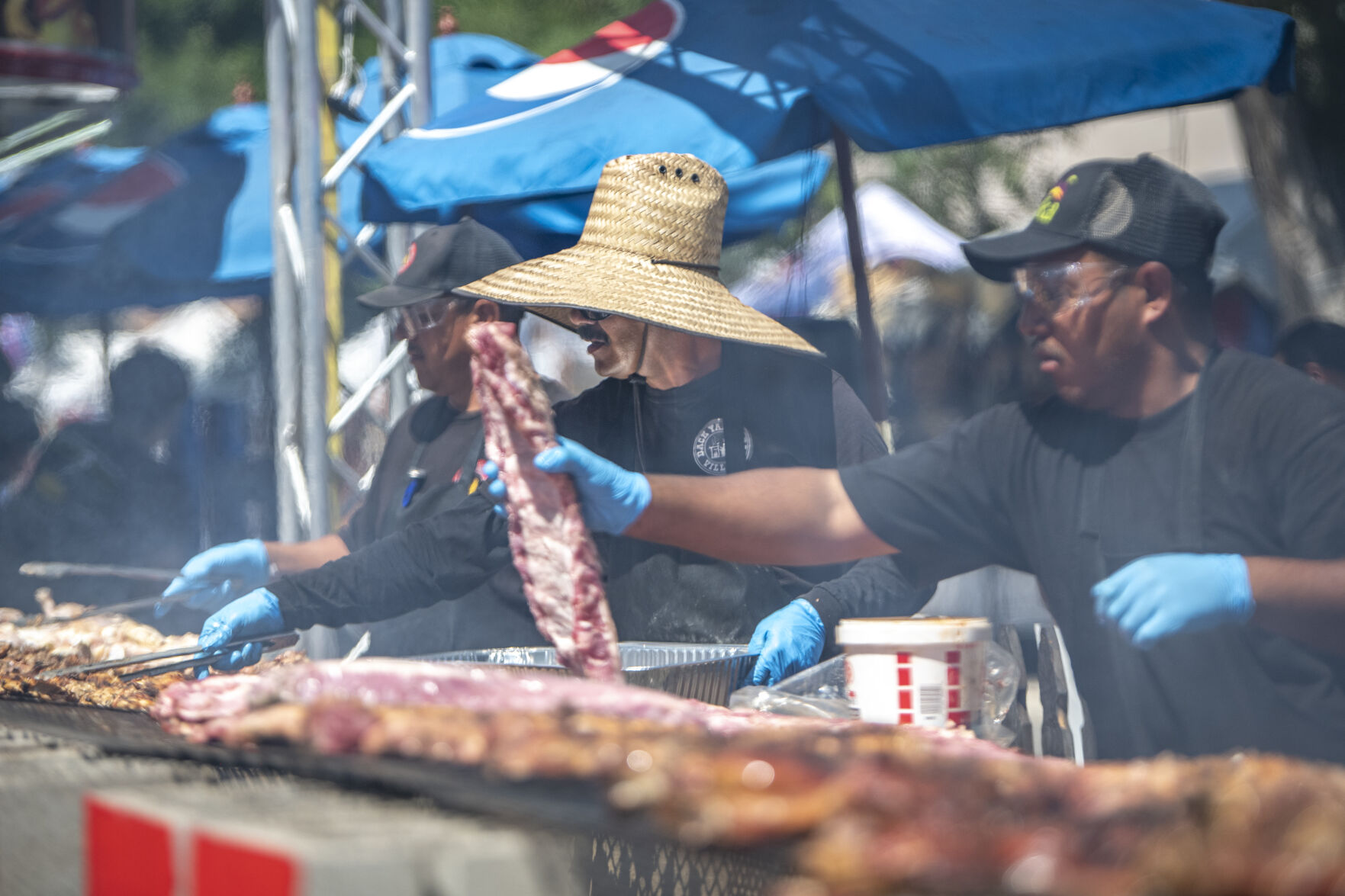 Slabs of meat are cooked on an enormous grill during the first day of the Colorado State Fair in Pueblo, Colo. on Friday, August 25, 2023. (Gabi Broekema)