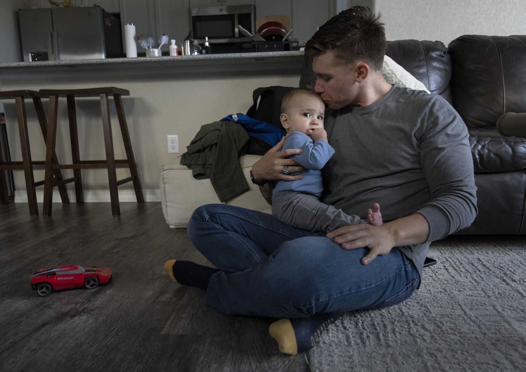 Z Cardenas kisses his 9-month-old son, Mateo Cardenas, after coming home from work at the Air Force Academy Friday, Aug. 18, 2023. Cardenas graduated from the Academy last Spring and now works there while Mateo’s mother, Sarah Swan is finishing this school year. (The Gazette, Christian Murdock) (Christian Murdock/The Gazette)