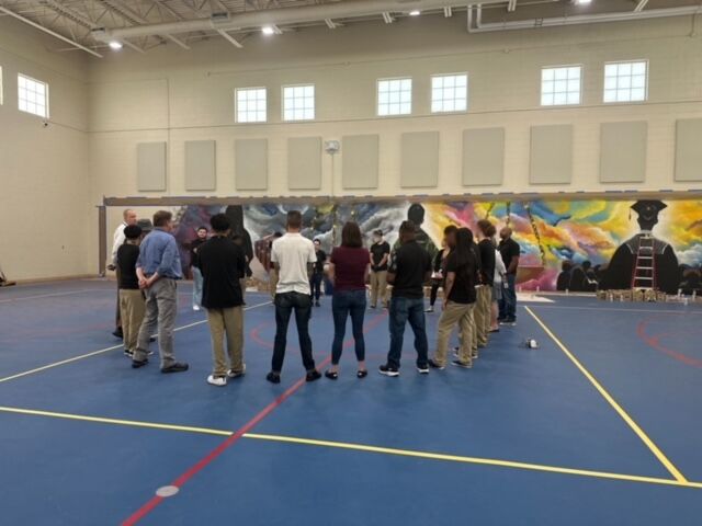 Teens incarcerated at Lakewood's Mount View Youth Services Center admire a mural they painted in the gymnasium. Mount View is a multipurpose center operated by the Colorado Department of Human Services, and it's purpose is to rehabilitate detained and committed youth through treatment, education and programming. (Courtesy of Heidi Bauer)