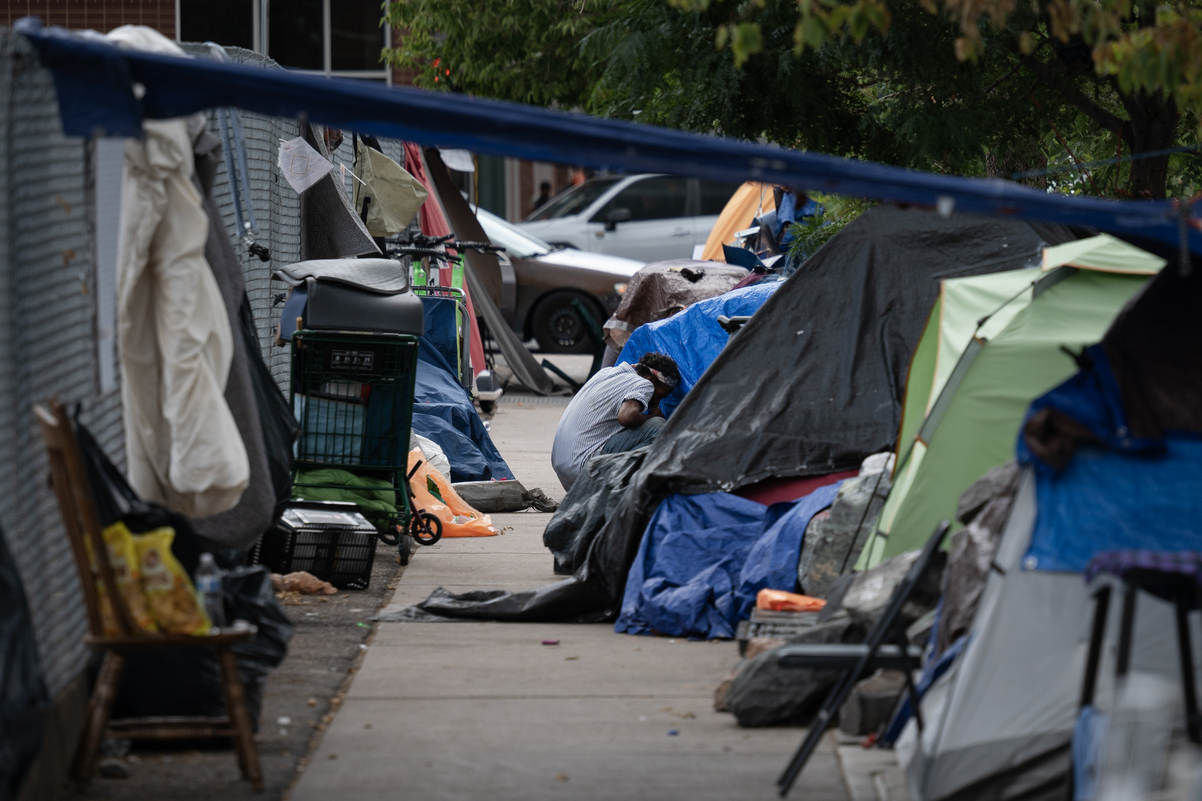 Tarps are Hund from tents to the adjacent fence at an encampment at 22nd Street and Stout Street on Thursday, Aug. 3, 2023, in Denver, Colo. (Timothy Hurst/Denver Gazette) (Timothy Hurst/Denver Gazette)