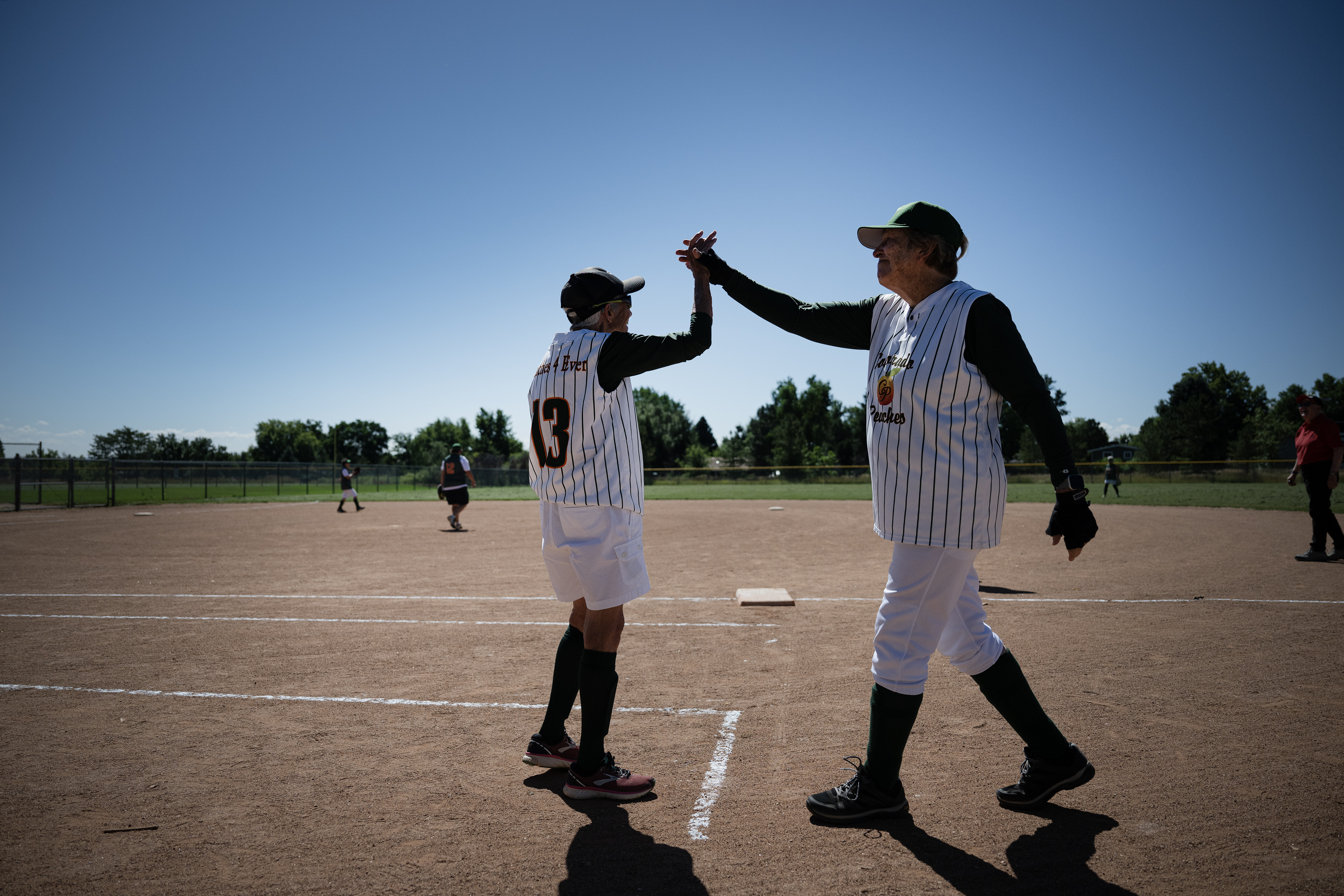 Colorado Peaches Turnovers player “Maggie” McCloskey (13) high fives teammate Midge Kral (62) after Kral was thrown out at first during a game against the Tarts during the Second Annual Gail Klock Memorial Peach Bowl on Tuesday, Aug. 29, 2023, at Addenbrooke Park in Lakewood, Colo. (Timothy Hurst/Denver Gazette) (TimHursttim.hurst@gazette.comhttps://secure.gravatar.com/avatar/aca82bd62b4ee425c598527cd6faa1b1?d=mm&r=g)