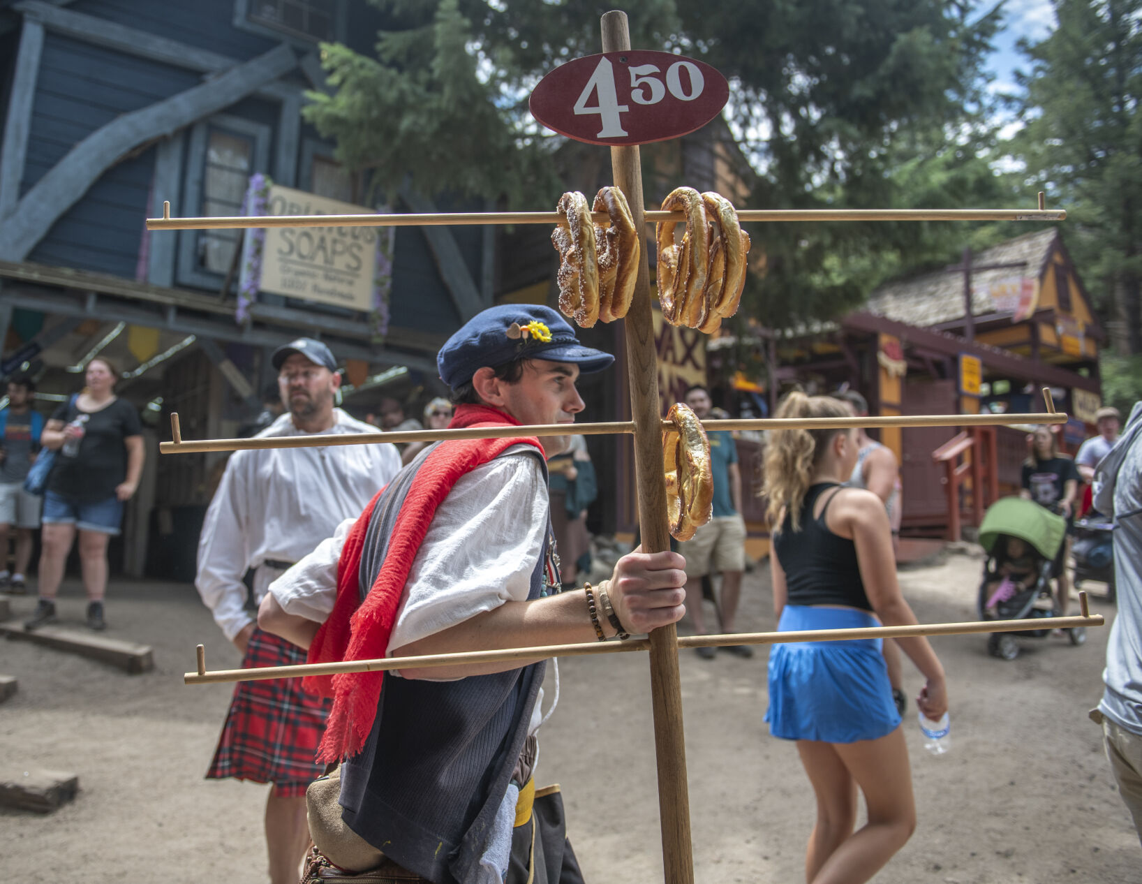 Sellers hoist popcorn and pretzels on large frames to sell to attendees of the Colorado Renaissance Festival in Colorado Springs, Co., on Saturday, July 29, 2023. (Gabi Broekema)