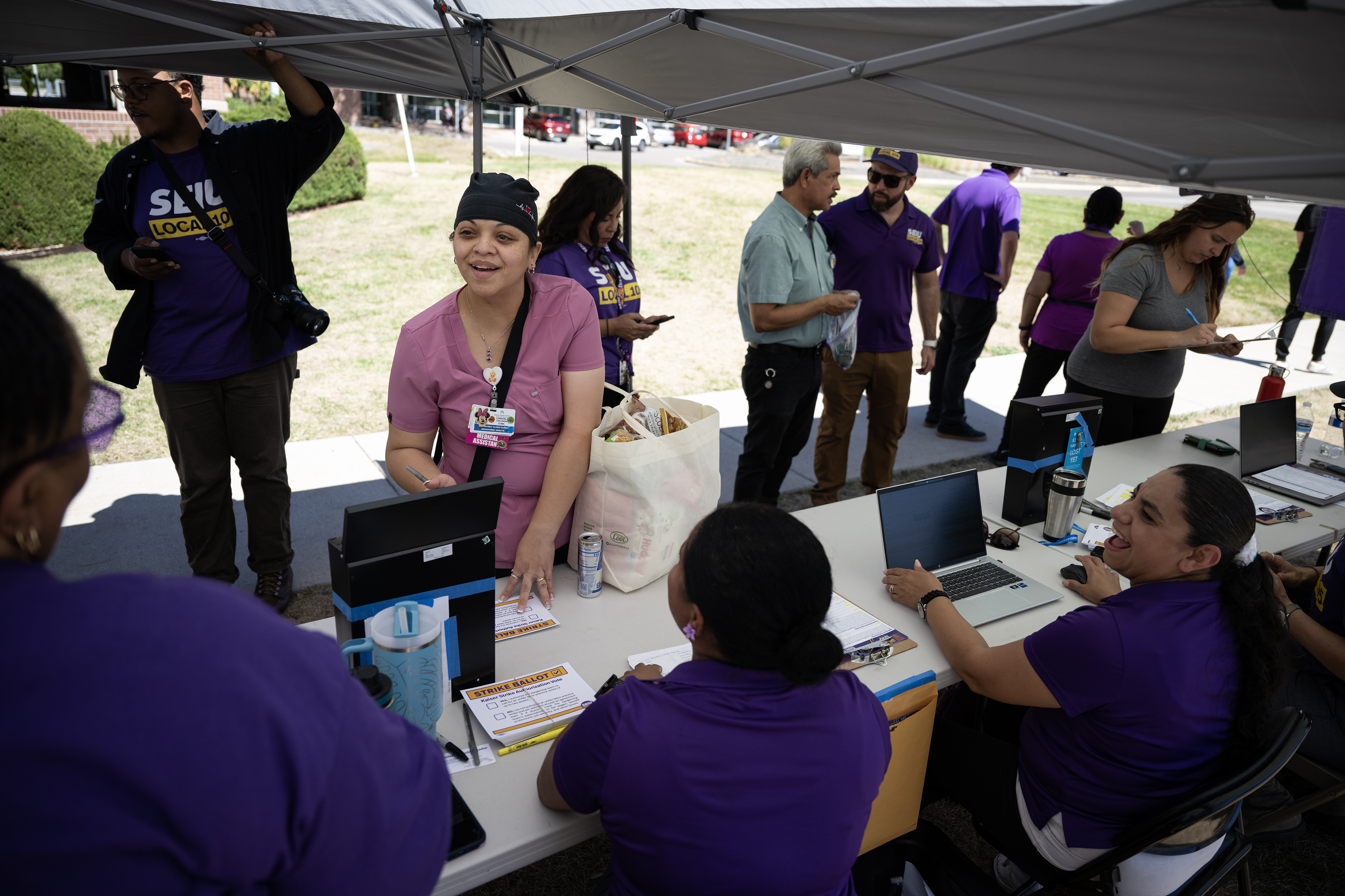 Kaiser Permanente medical assistant Christal Coluga shares a laugh with union reps while casting her vote to either authorize a strike or not at a voting tent set up by Service Employees International Union Local 105 Denver, outside of the Kaiser Permanente Franklin Medical Offices on Thursday, Aug. 31, 2023, in Denver. (Timothy Hurst/Denver Gazette) (TimHursttim.hurst@gazette.comhttps://secure.gravatar.com/avatar/aca82bd62b4ee425c598527cd6faa1b1?d=mm&r=g)