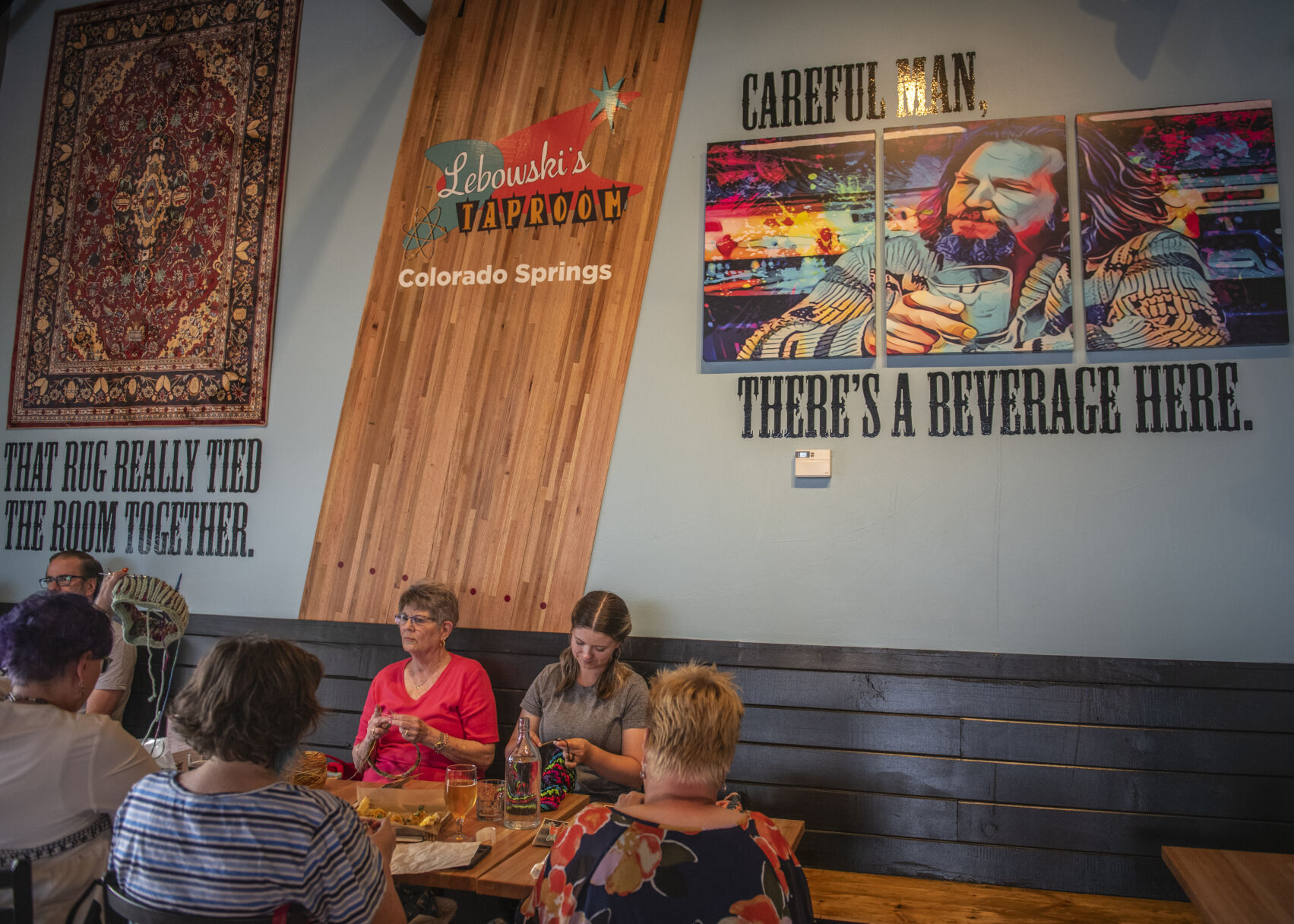 A knitting group chats over drinks and dinner at Lebowski's Taproom in Colorado Springs, Colo. on Wednesday, August 23, 2023. The group had stumbled upon the restaurant just a few days earlier and come back for more. (Gabi Broekema)