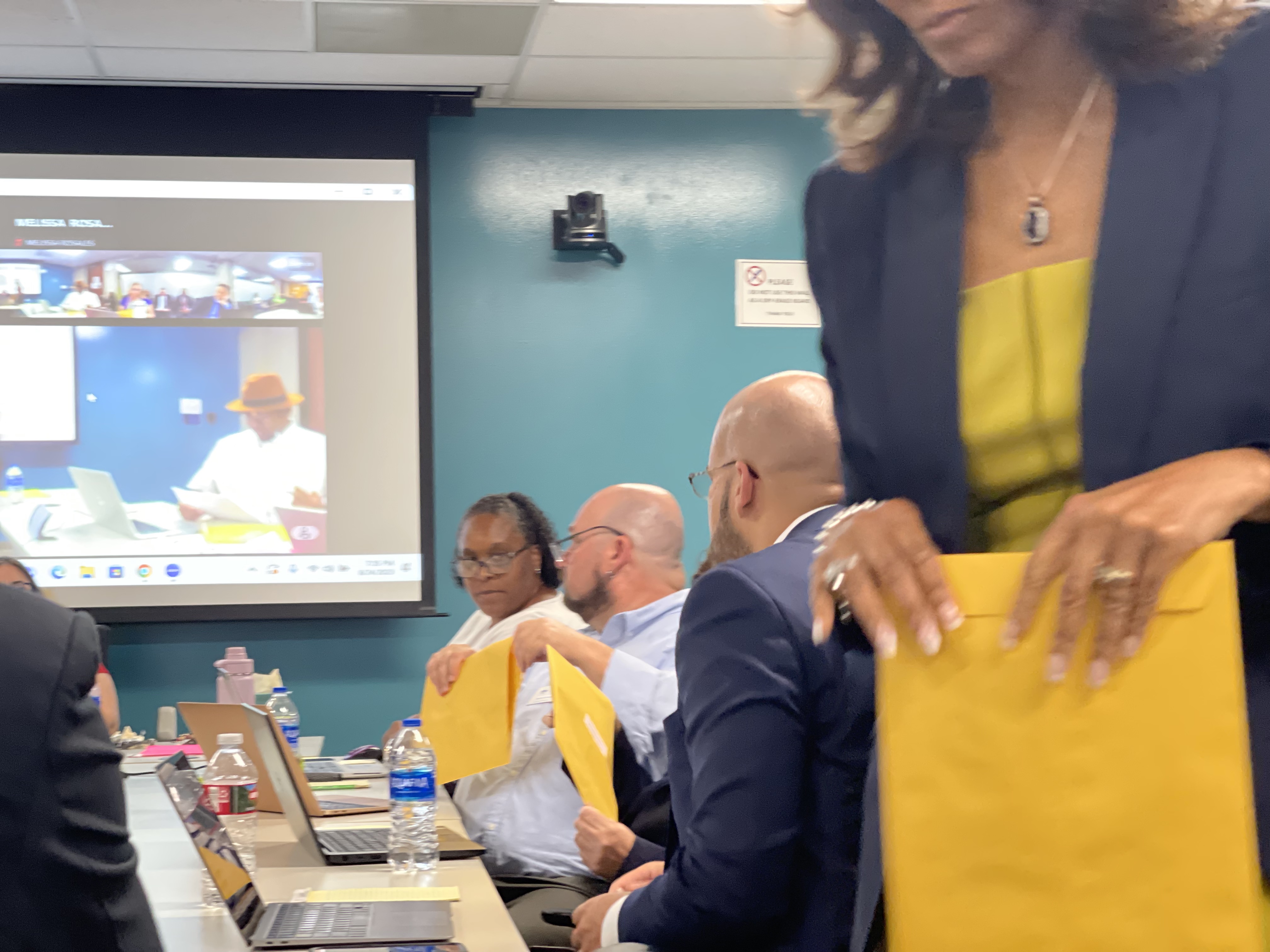 Denver Public Schools Deputy Chief of Staff Deborah Staten (front) passes out copies of an internal report to the Board of Education on Aug. 24, 2023, that shows fired Principal Kurt Dennis did not engage in the “legal definitions of unlawful discrimination, harassment, or retaliation” when placing McAuliffe International students in a de-escalation room. (NicoBrambilanico.brambila@denvergazette.comhttps://denvergazette.com/content/tncms/avatars/4/ec/74a/4ec74aa2-71b0-11ed-af6f-0f0ae7acf7b0.d52fca74e95503d77da50127c9ff4e2d.png)
