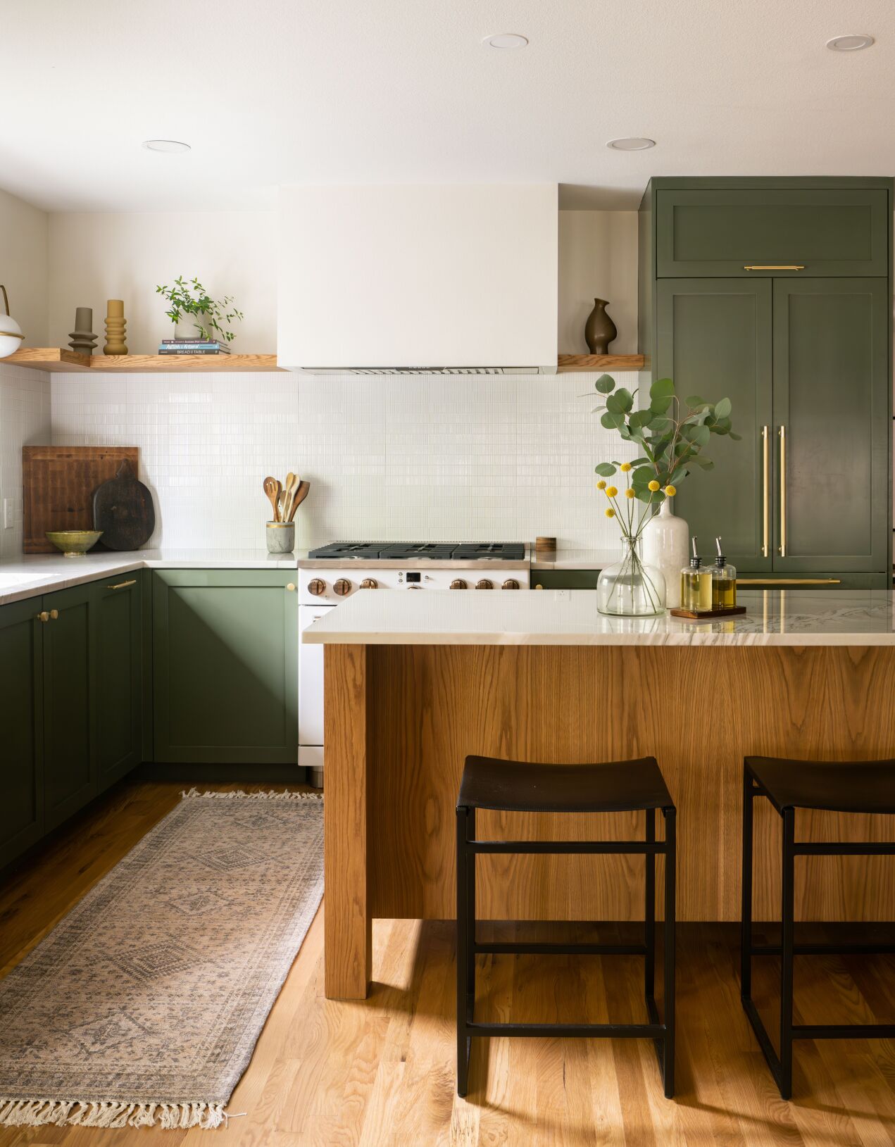 For this 1952 bungalow in Austin, Texas, interior designer Sara Malek Barney moved a wall to double the kitchen’s size, then updated cabinets and finishes. She incorporated the once-hidden-now-open kitchen into the home’s main living area through wall color and flooring choices. (Madeleine Landry)