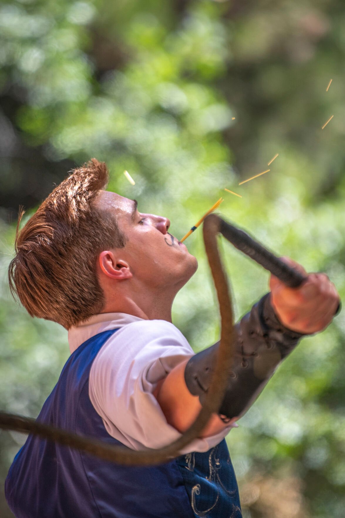 Jaques the Whipper performs one of his final acts in his show, breaking dry spaghetti noodles as he holds them in his mouth on the Crown Stage at the Colorado Renaissance Festival in Colorado Springs, Co., on Saturday, July 29, 2023. (Gabi Broekema)