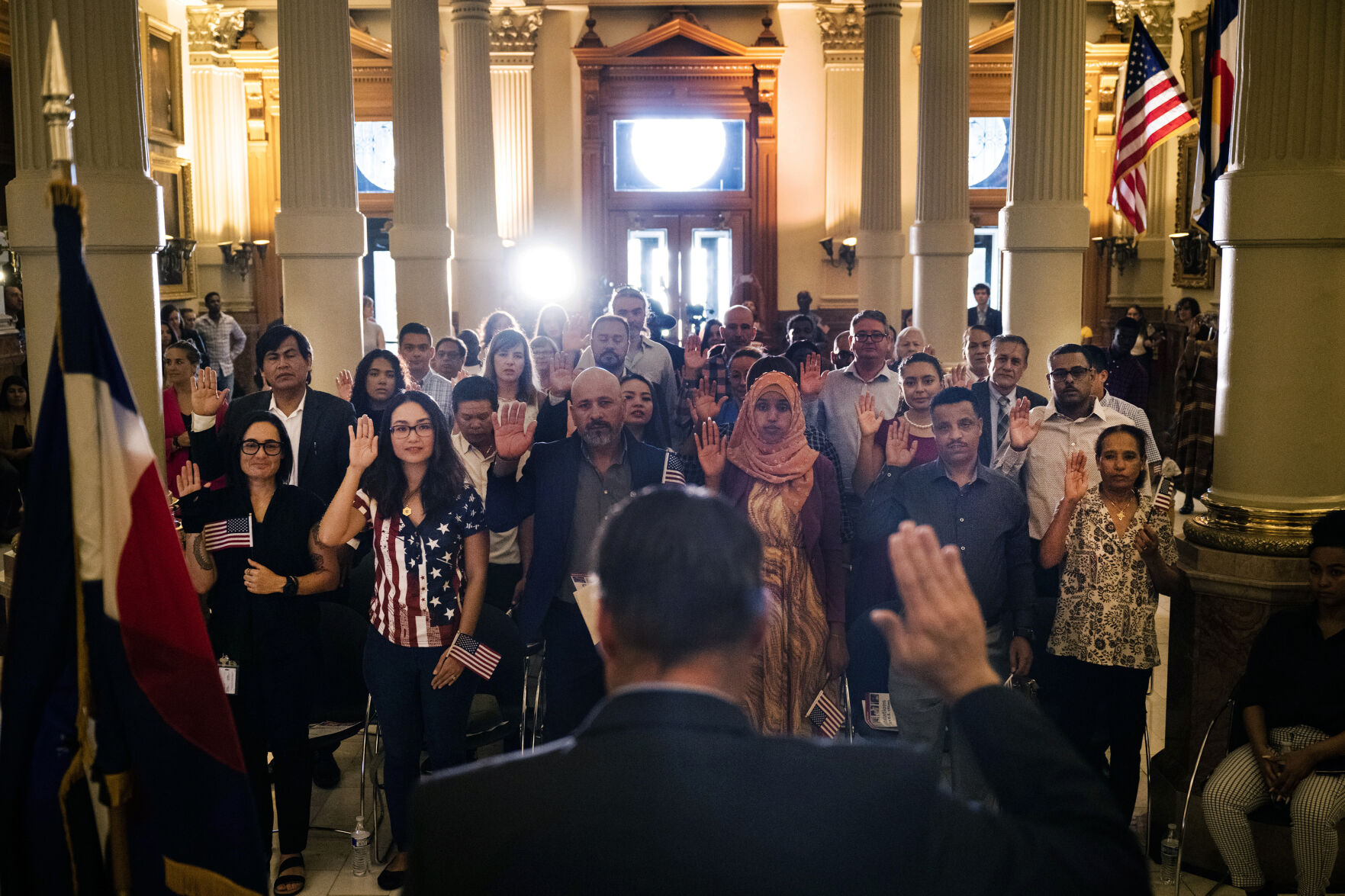 United States Citizenship and Immigration Services Kansas City district director David Douglas, center, administers the Oath of Allegiance to 35 new U.S. citizens during a naturalization ceremony at the Colorado State Capitol building on Tuesday, Aug. 1, 2023, in Denver, Colo. The 35 new citizens came from 20 different countries in the ceremony held at the Capitol in celebration of the 147th anniversary of President Ulysses S. Grant signing a proclamation that officially declared Colorado a state. (Timothy Hurst/Denver Gazette) (Timothy Hurst/Denver Gazette)