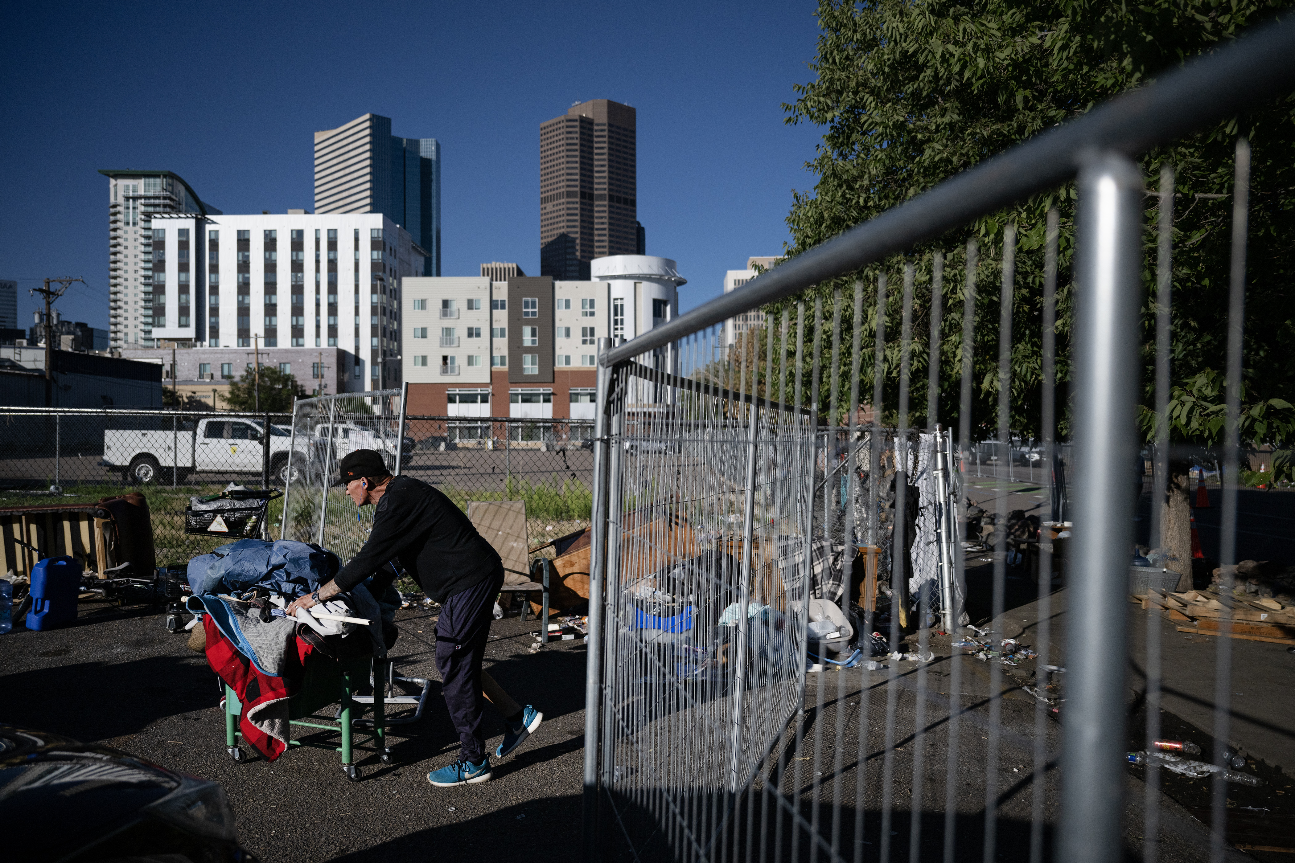 A man who preferred to not be identified by name pushes a cart of belongings through the opening left in the fence erected around his and other’s campsites during the first encampment sweep under the Johnston administration at an encampment at 22nd and Stout streets on Friday morning, Aug. 4, 2023, in Denver, Colo. (Timothy Hurst/Denver Gazette) (TimHursttim.hurst@gazette.comhttps://secure.gravatar.com/avatar/aca82bd62b4ee425c598527cd6faa1b1?d=mm&r=g)