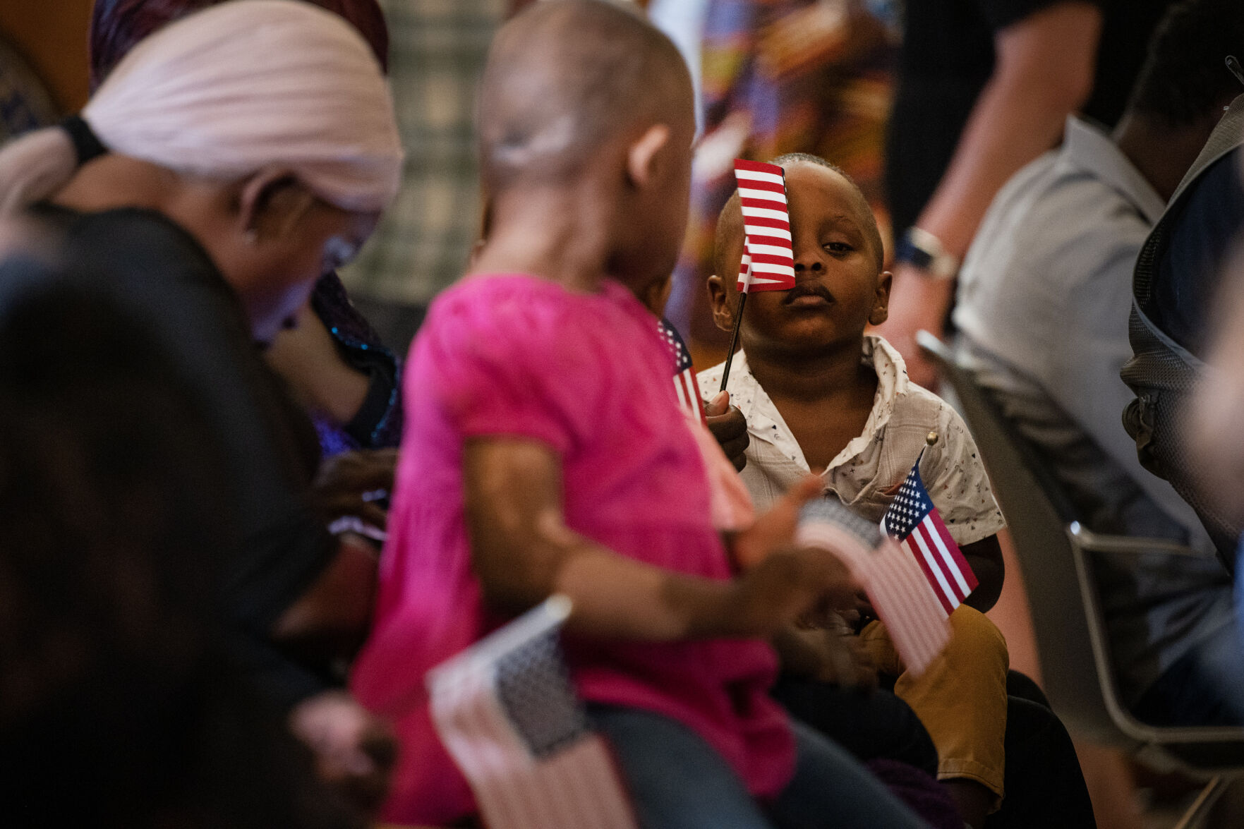 Alphonso Mah, 2, plays with small U.S. flags while waiting to watch his grandmother Beatrice Suku become a U.S. citizen during a naturalization ceremony at the Colorado State Capitol building on Tuesday, Aug. 1, 2023, in Denver, Colo. 35 new U.S. citizens from 20 different countries took the Oath of Allegiance from United States Citizenship and Immigration Services Kansas City district director David Douglas, held at the Capitol in celebration of the 147th anniversary of President Ulysses S. Grant signing a proclamation that officially declared Colorado a state. (Timothy Hurst/Denver Gazette) (TimHursttim.hurst@gazette.comhttps://secure.gravatar.com/avatar/aca82bd62b4ee425c598527cd6faa1b1?d=mm&r=g)