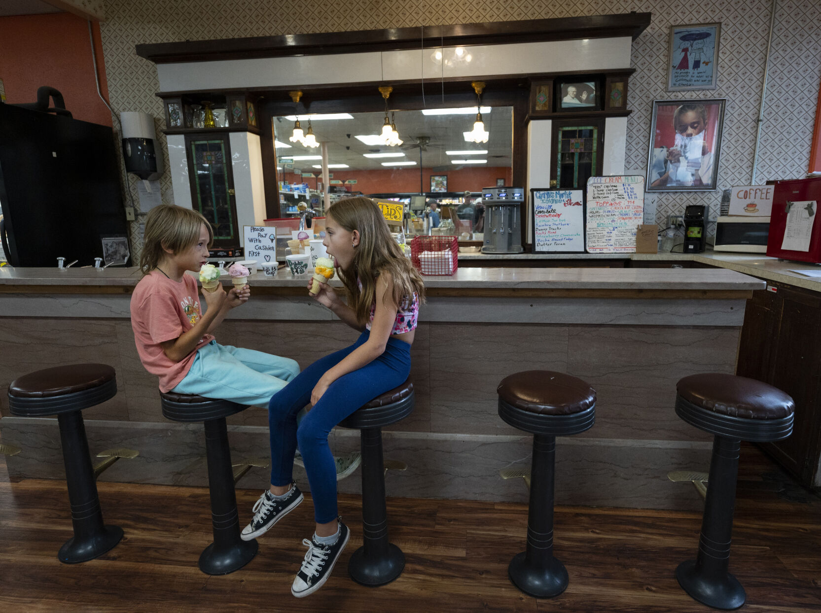 Cousins Blanton Negley, 7, left, and Ali Menegatti, 9, enjoy a treat at the old soda fountain inside Charlie’s MarketTuesday, Aug. 1, 2023, in La Veta, Colorado. The market and soda bar have been on South Main Street since 1937. The two were visiting their grandmother, Alaine Byers, who moved to the area 23 years ago from Boulder County. (The Gazette, Christian Murdock) (Christian Murdock/The Gazette)