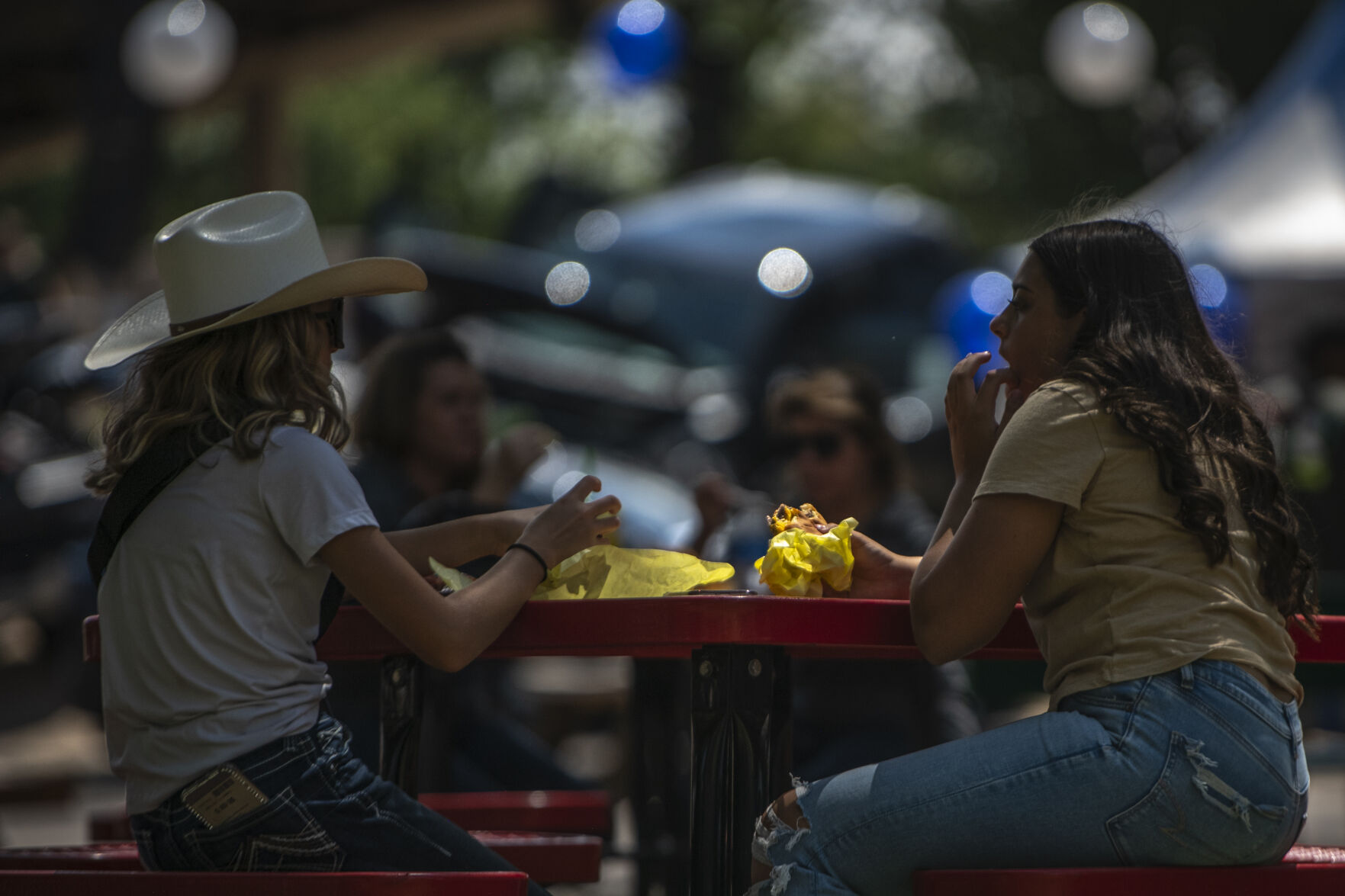 Visitors of the Colorado State Fair enjoy burgers and other fair food at Colorado State Fairgrounds in Pueblo, Colo. on Friday, August 25, 2023. (Gabi Broekema)