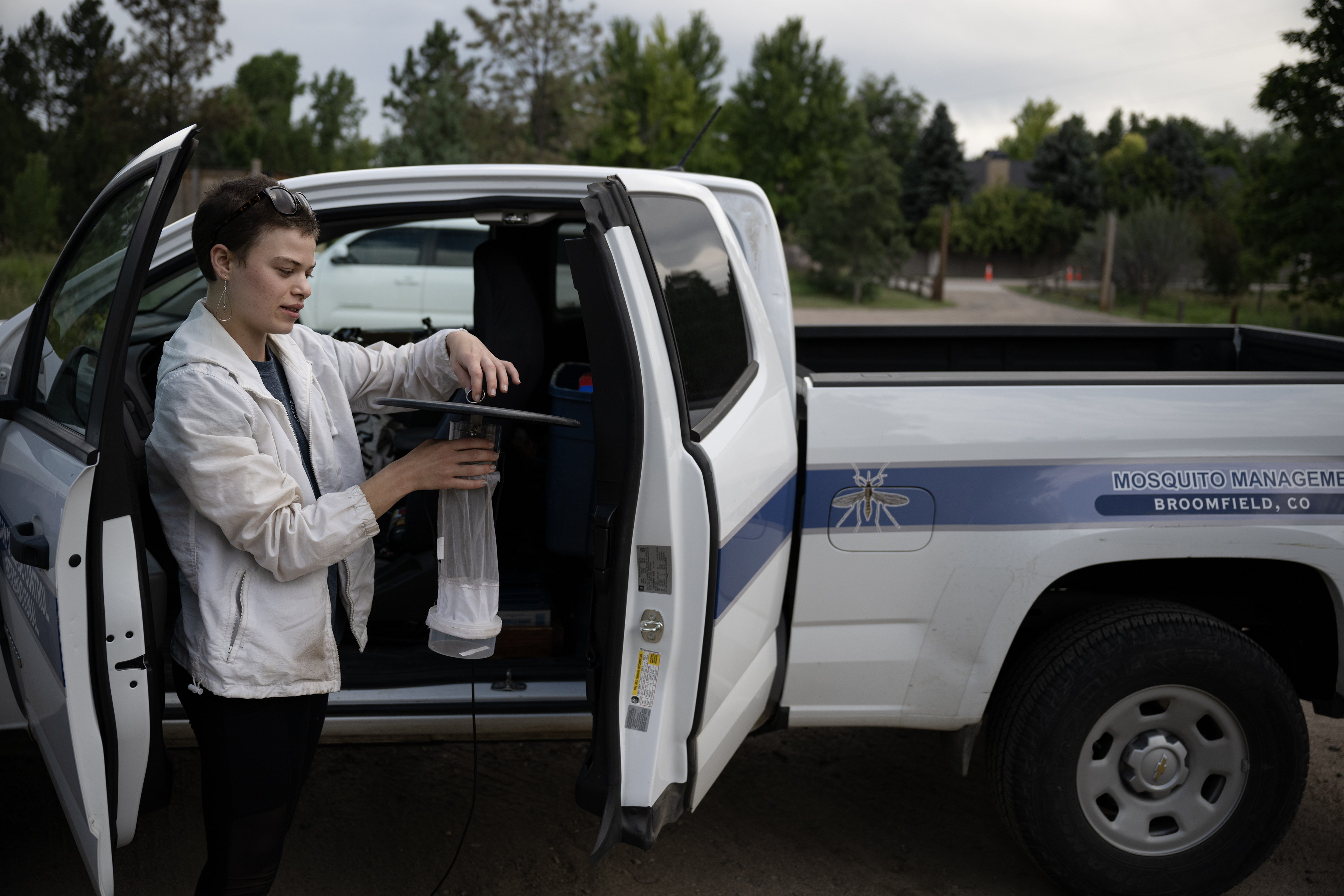 Surveillance technician Sydney Schmelzer sets up a mosquito trap before heading down to an area of thick vegetation near a stream to set the trap for the night on Thursday, Aug. 10, 2023, at Rollin D. Barnard Equestrian Park in Greenwood Village, Colo. (Timothy Hurst/Denver Gazette) (TimHursttim.hurst@gazette.comhttps://secure.gravatar.com/avatar/aca82bd62b4ee425c598527cd6faa1b1?d=mm&r=g)