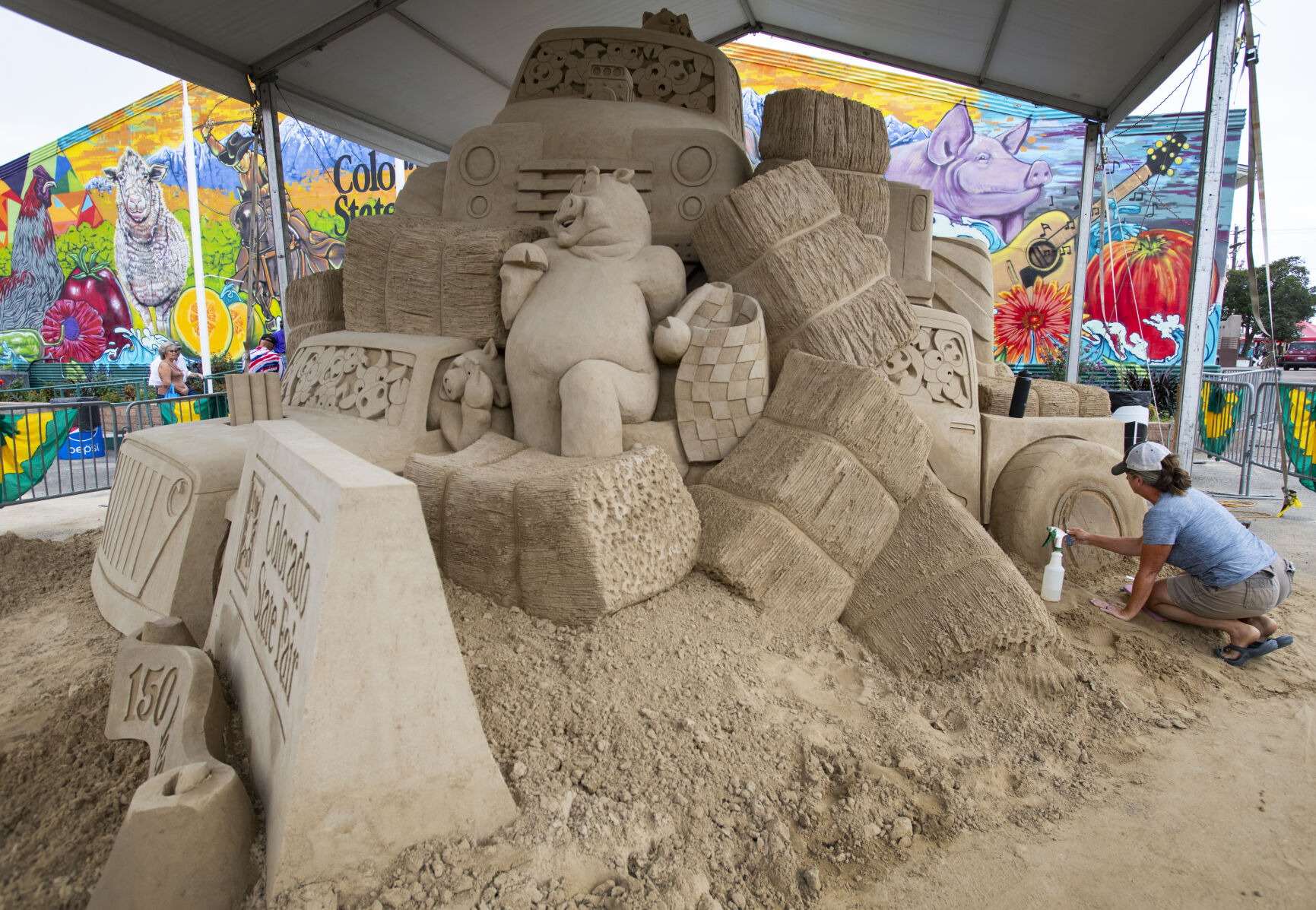 Brandi Glenn and her husband, Greg Glenn, not pictured, work on a giant 150-ton sand sculpture for the 150 anniversary of the Colorado State Fair Friday, Aug. 26, 2022, during the first day of the fair in Pueblo, Colo. The couple plan to finish the project by Wednesday, about 2 1/2 weeks after starting it. The 150th year of the state fair runs through Sept. 5, 2022. (The Gazette, Christian Murdock) (Christian Murdock/The Gazette)