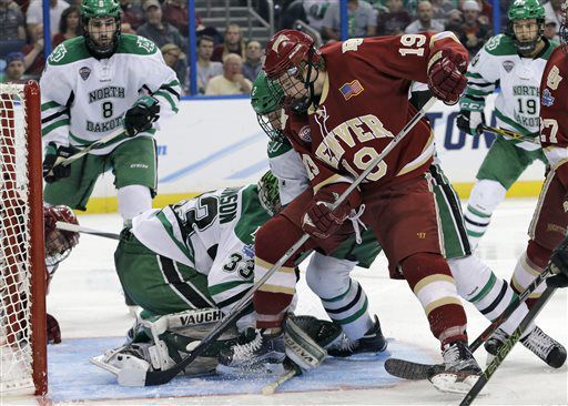 Denver forward Troy Terry (19) digs at a loose puck in front of North Dakota goalie Cam Johnson (33) during the second period of an NCAA Frozen Four men's college hockey semifinal, Thursday, April 7, 2016, in Tampa, Fla. (AP Photo/Chris O'Meara) (Chris O'Meara)