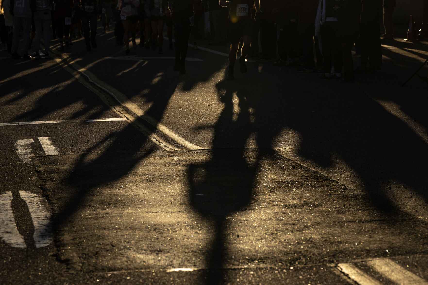 Runner cast shadows on the pavement as they take off from the starting line of the Pikes Peak Ascent on Saturday, Sept. 16, 2023. (Parker Seibold, The Gazette) (Parker Seibold)