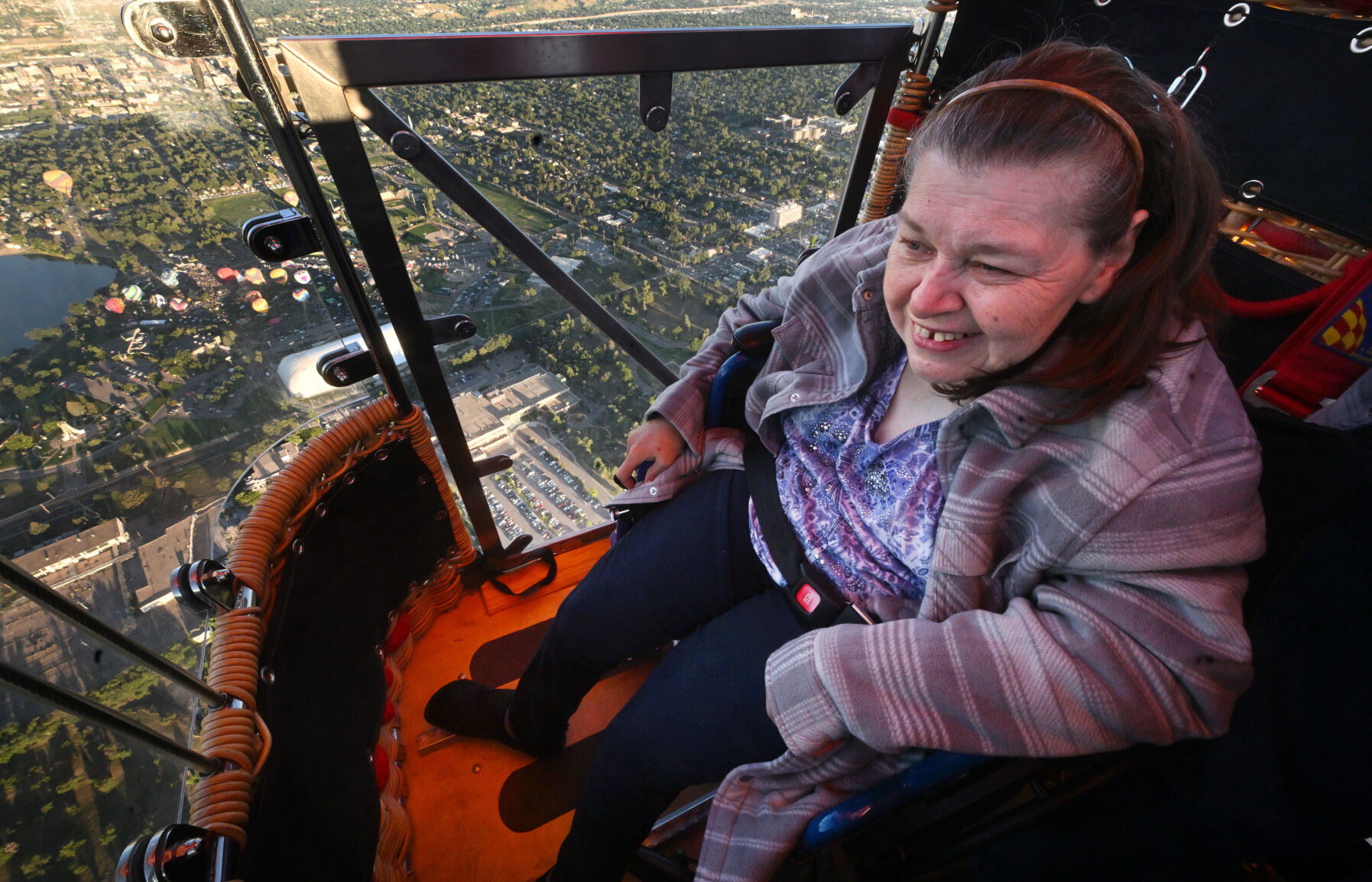 Ginger Gustafson has a birds’ eye view of Colorado Springs during the Colorado Springs Labor Day Lift Off. Gustafson became the first wheelchair-bound person to take flight in Colorado Springs in the specialized balloon designed for people with disabilities on Monday, Sept. 4, 2023. Pilot Mike “Heff” Heffron, pilot of the Coddiwomple, has the only balloon like it in the United States. (Photo by Jerilee Bennett, The Gazette)