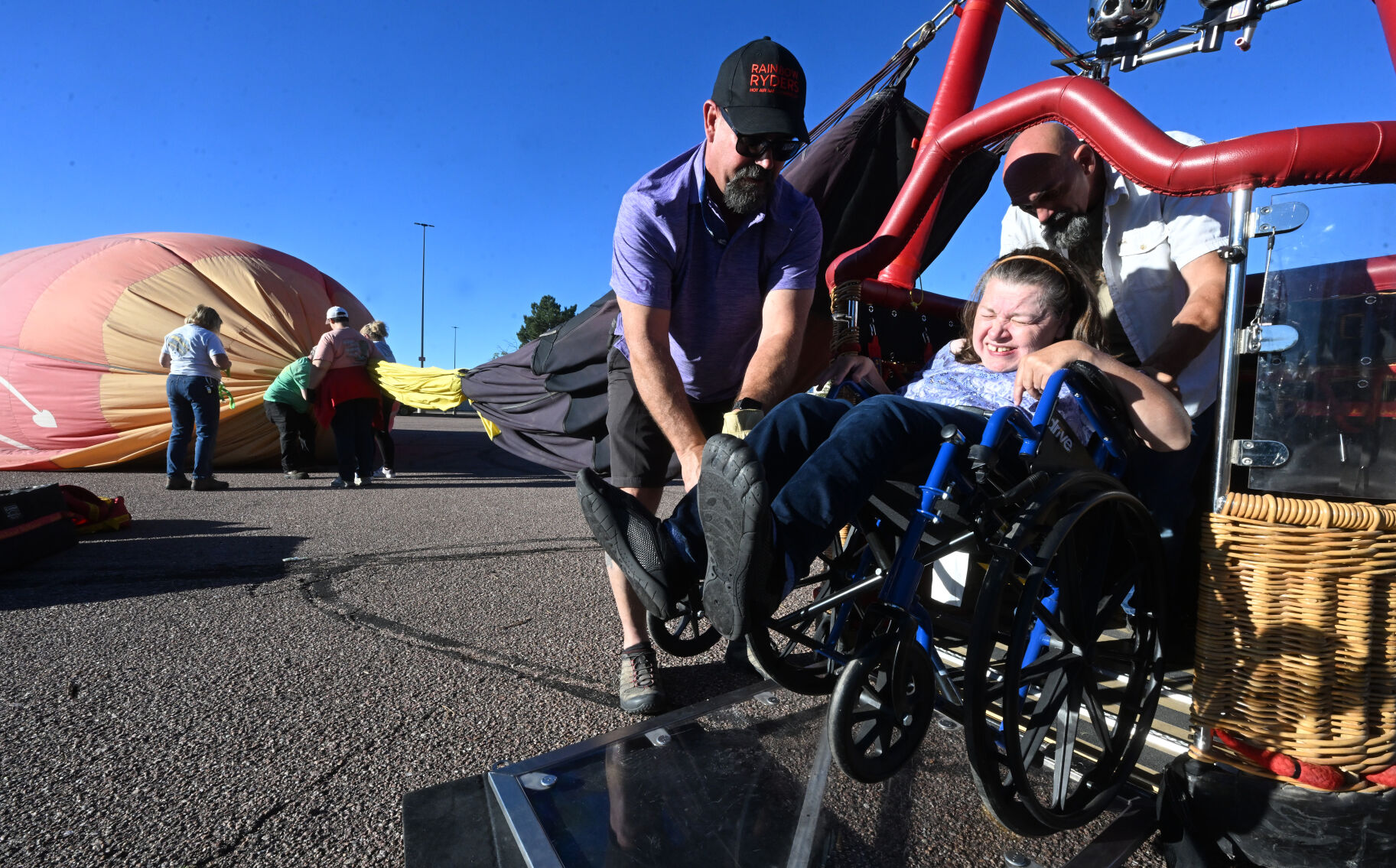 Pilot Mike “Heff” Heffron and Rick Gustafson help Ginger Gustafson after the balloon ride of her life during the Colorado Springs Labor Day Lift Off. Gustafson became the first wheelchair-bound person to take flight in Colorado Springs in the specialized balloon designed for people with disabilities on Monday, Sept. 4, 2023. (Photo by Jerilee Bennett, The Gazette)
